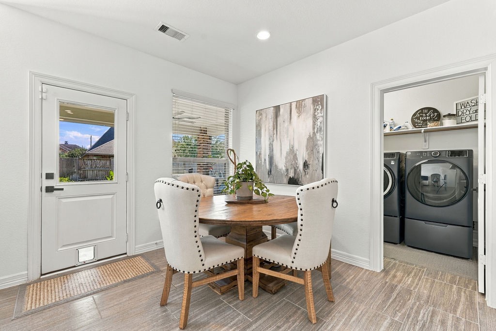 Bright and inviting breakfast area, large window for natural light, and convenient access to a modern laundry room with high-efficiency washer and dryer.