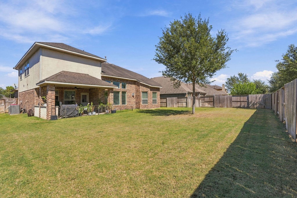 Spacious backyard with a well-maintained lawn, perfect for outdoor activities, featuring a covered patio ideal for relaxation and entertaining.