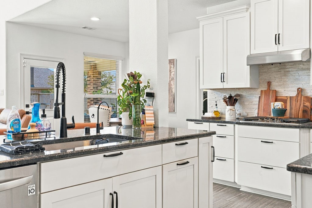 Bright kitchen with sleek white cabinetry, modern fixtures, and a spacious island, perfect for culinary enthusiasts.