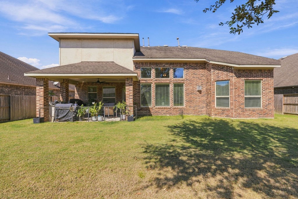 Spacious backyard with a covered patio and brick exterior, perfect for outdoor entertaining and relaxation.