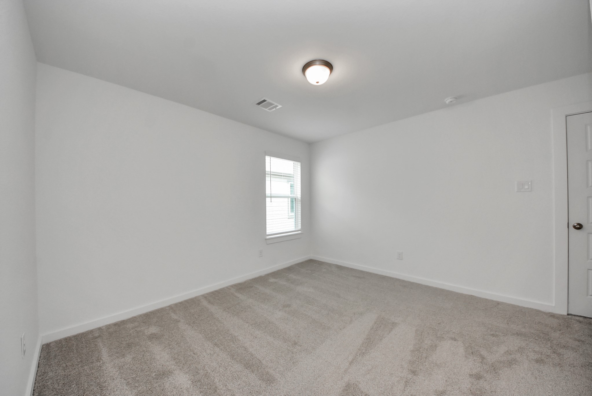 Secondary bedroom features plush carpeting, large windows that let in plenty of natural light, bright paint, and spacious closets.