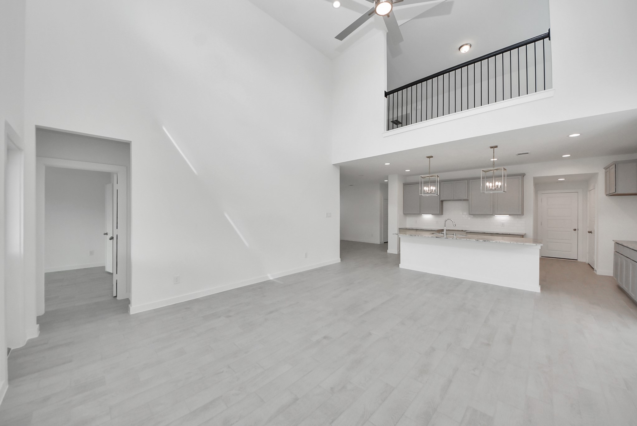 Welcome family and guests to your charming living room! With its high ceilings, recessed lighting, ceiling fan, custom paint, beautiful flooring, and large windows that let in abundant natural light, this room is perfect for gatherings.