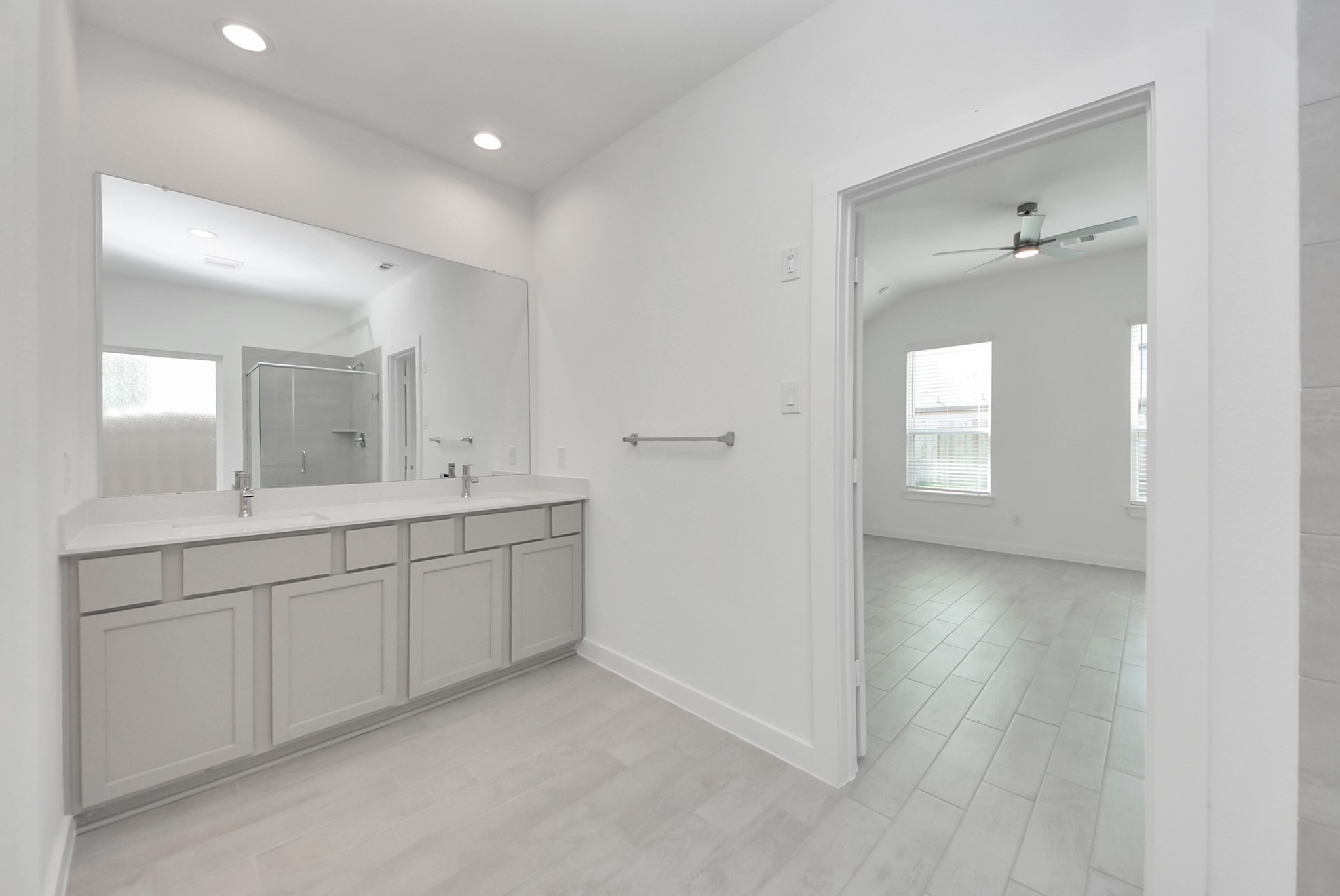 Escape to a spa-like oasis in this primary bathroom. Enjoy a walk-in shower with tile surround, a separate garden tub with custom detailing, and an elegant vanity featuring light countertops, modern hardware, and beautiful vanity lights. Experience luxury and relaxation in every detail.