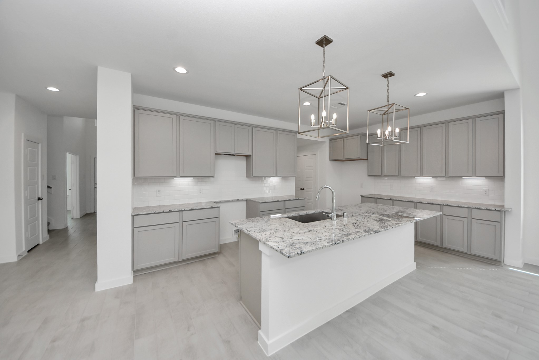 This kitchen is by far any chefs dream! This spacious kitchen features high ceilings, stained wood cabinets, granite countertop, SS appliances, modern tile backsplash, recessed lighting, extended counter space, granite kitchen island with double sink, and space for breakfast bar, and a walk-in pantry all overlooking your huge family room.
