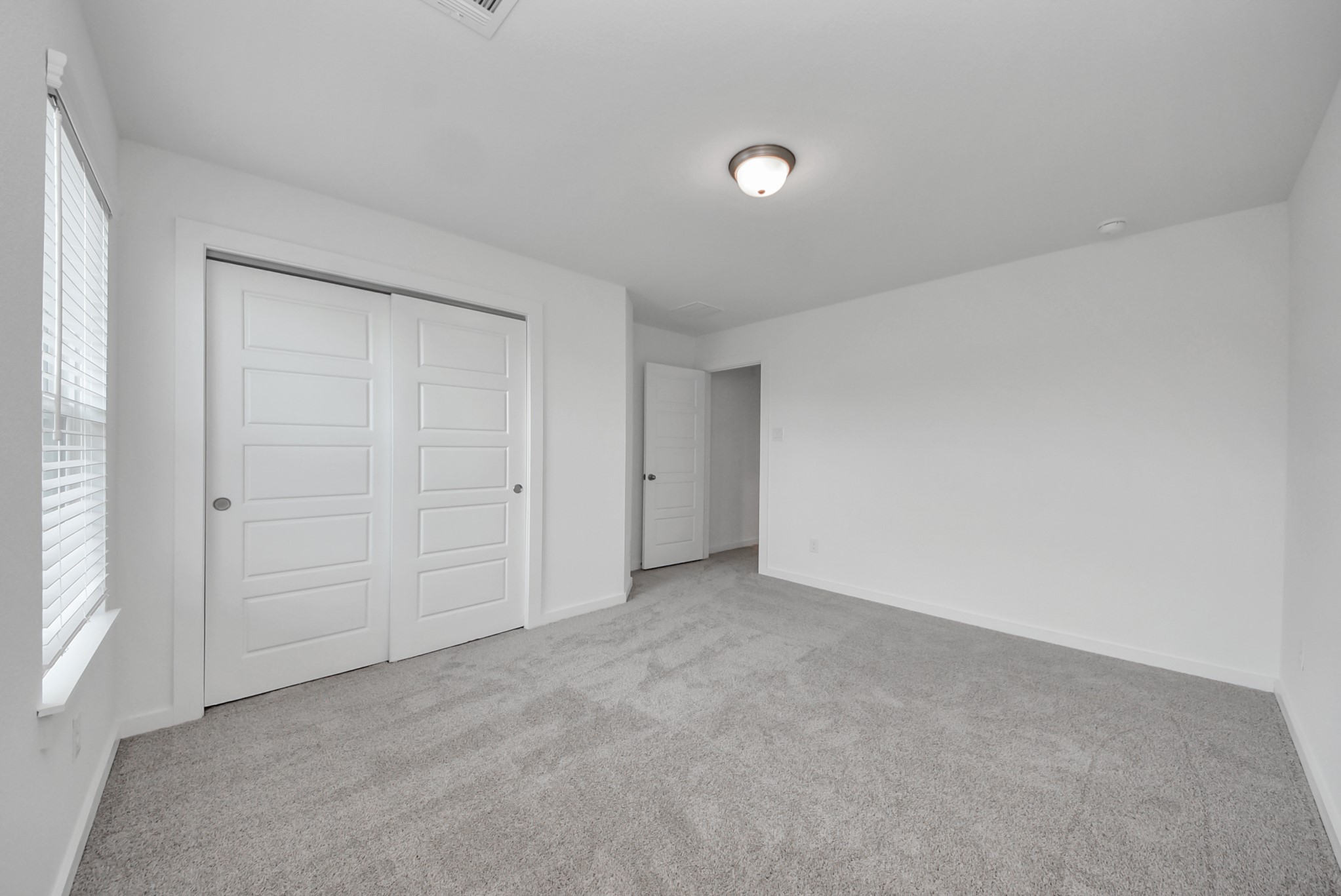 Generously sized secondary bedrooms featuring spacious closets, soft and inviting carpeting underfoot, large windows allowing plenty of natural light, and the added touch of privacy blinds for your personal retreat.