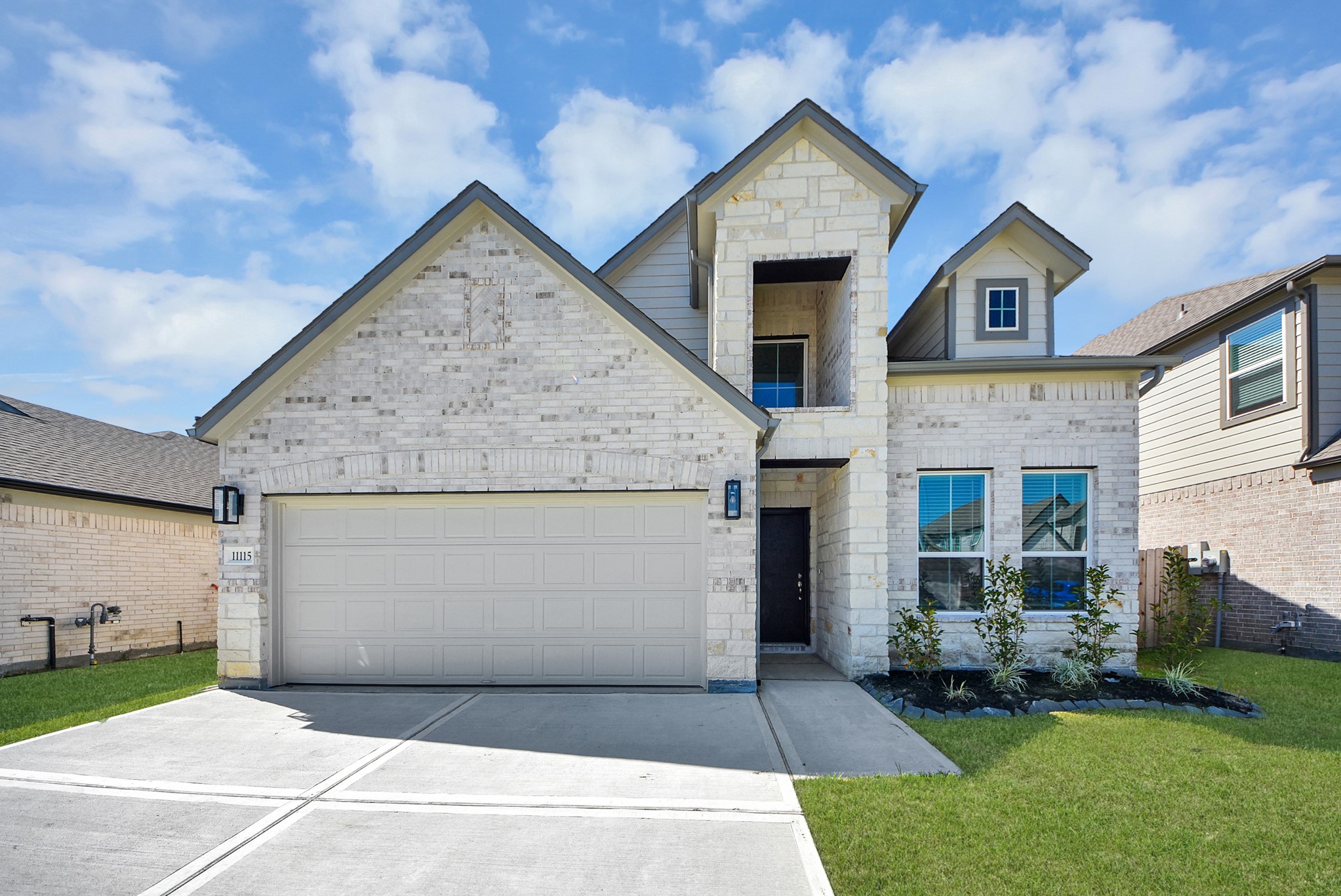 This home boasts lush green grass and meticulous landscaping. Its premium elevation showcases an exquisite blend of brick and stone features, complemented by modern coach lighting