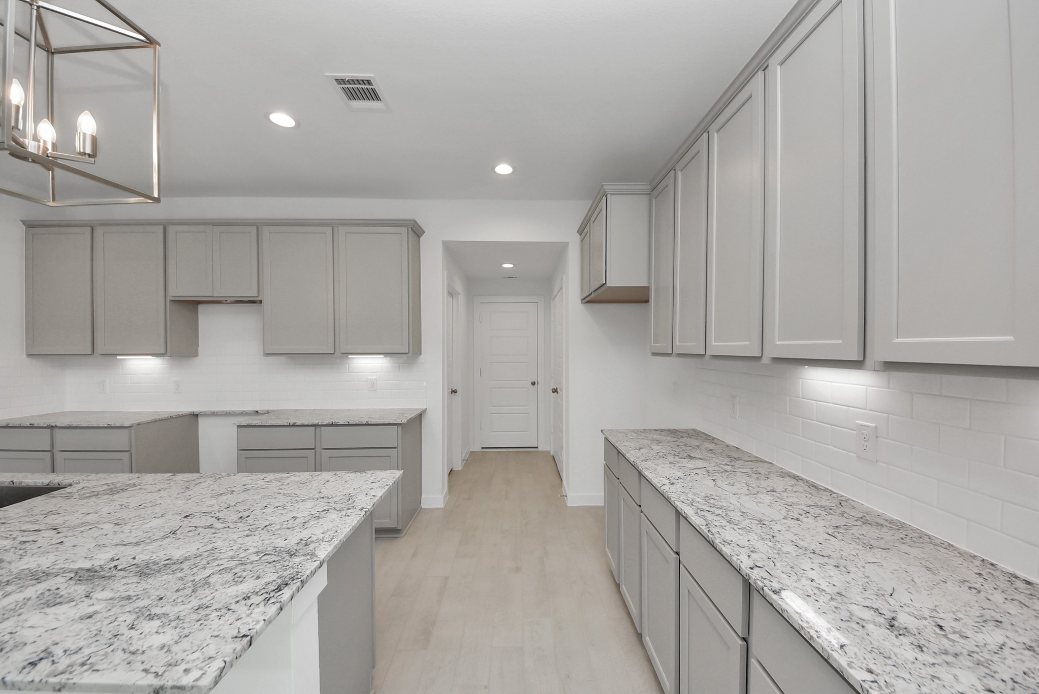 Step into a dream realized with this generously spacious kitchen! A massive granite island takes center stage, complemented by high ceilings and soft-close cabinets. The granite countertops, stainless steel appliances, sleek tile backsplash, and recessed lighting complete the elegant design.