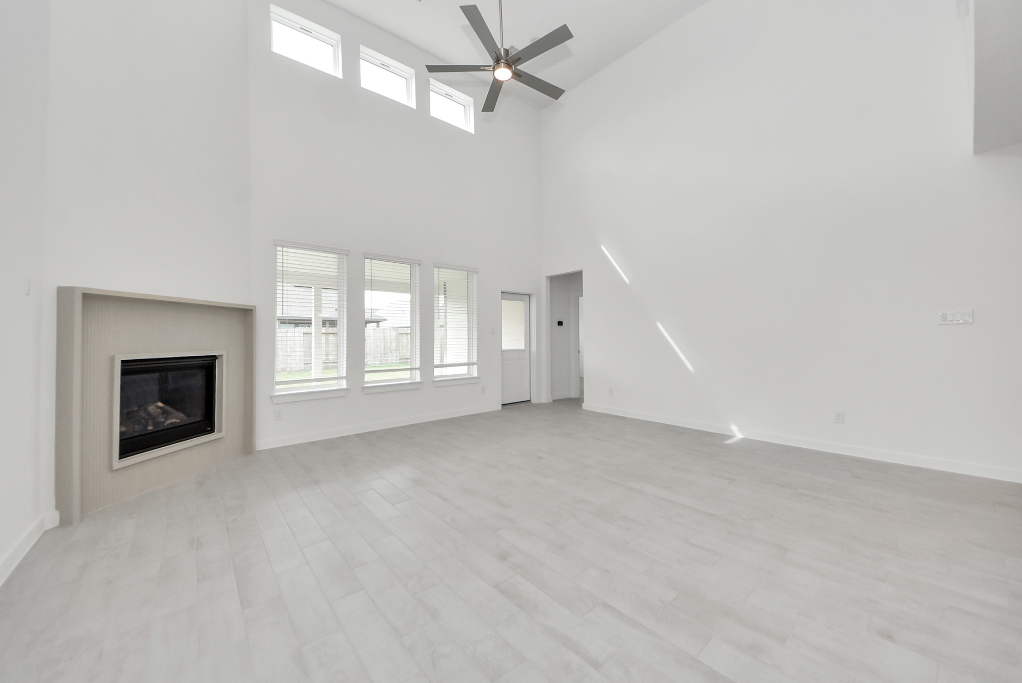 Gather the family and guests together in your lovely living room! Featuring soaring high ceilings, recessed lighting, ceiling fan, custom paint, gorgeous floors, and large windows that provide plenty of natural lighting throughout the day.