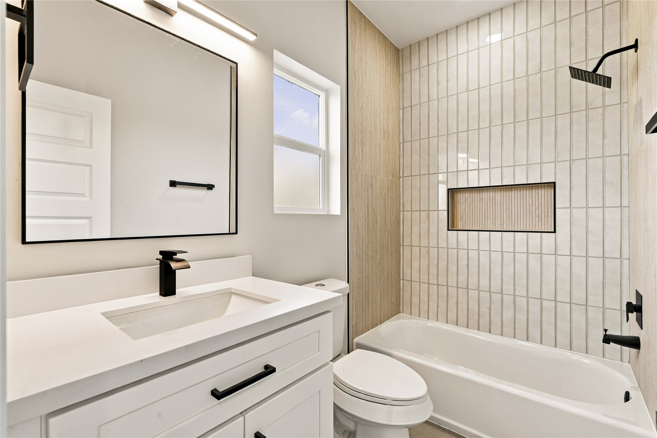 Sparkling full bath  pristine secondary bath complete with custom tilework and deep soaking tub.