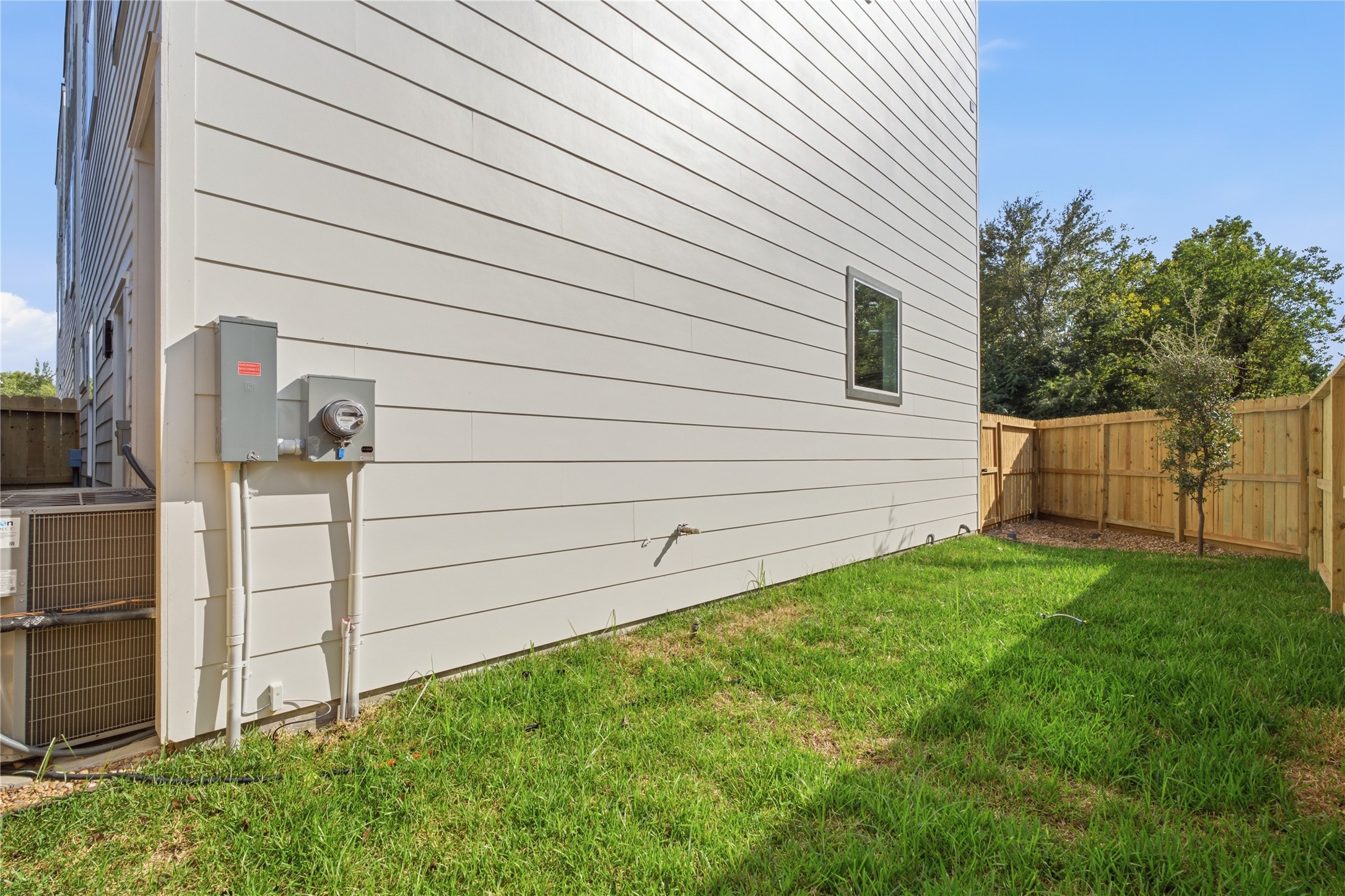 Private green yard  fully fenced grassy lawn perfect for garden projects, afternoon sunshine, and pet fun.