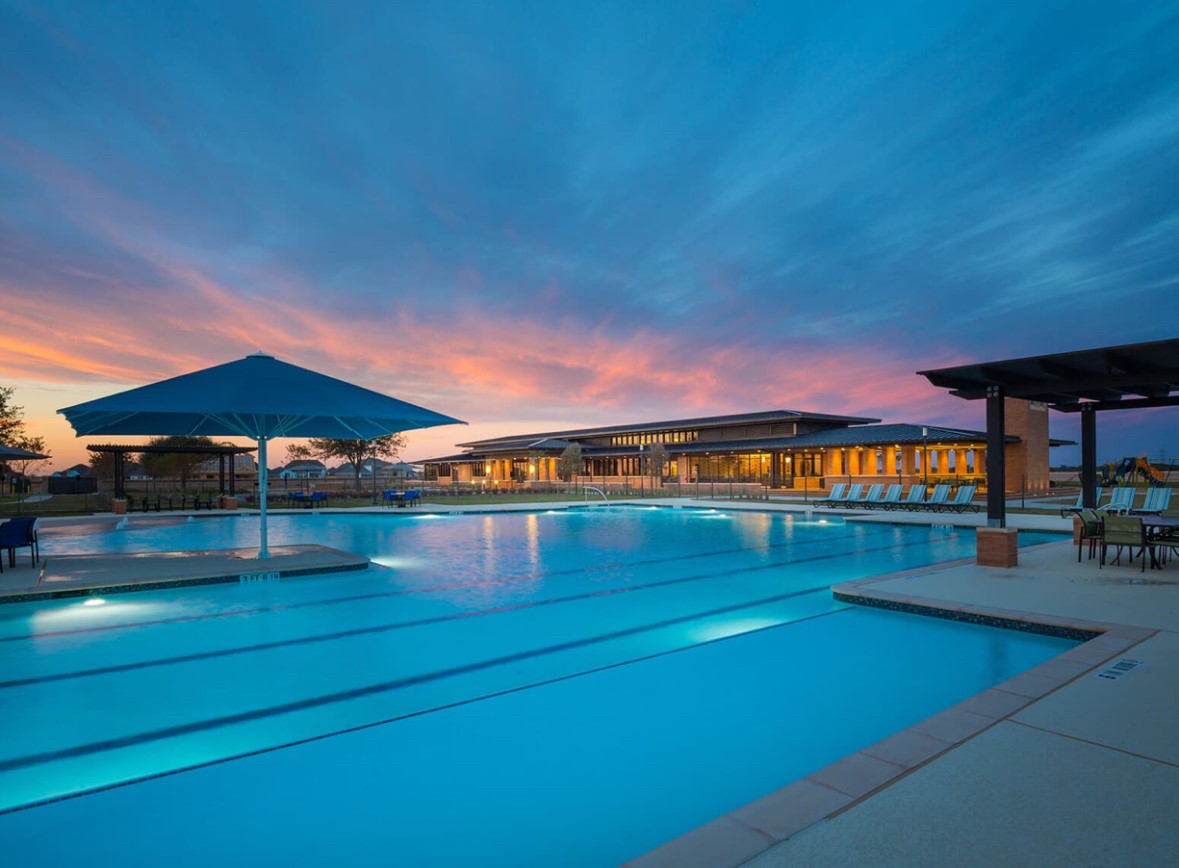 Enjoy resort-style living in Elyson with a beautiful community swimming pool, expansive pool deck, and inviting spaces for relaxation.