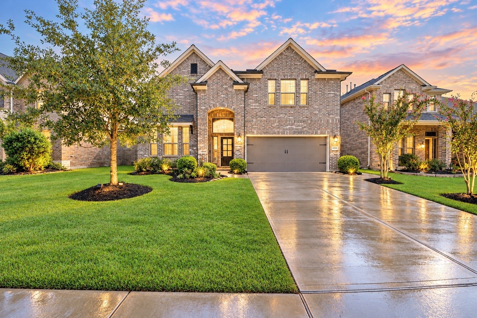 Beautiful two-story Chesmar home in the master-planned Elyson community, featuring an attractive brick and stone exterior, manicured landscaping, and an attached two-car garage.