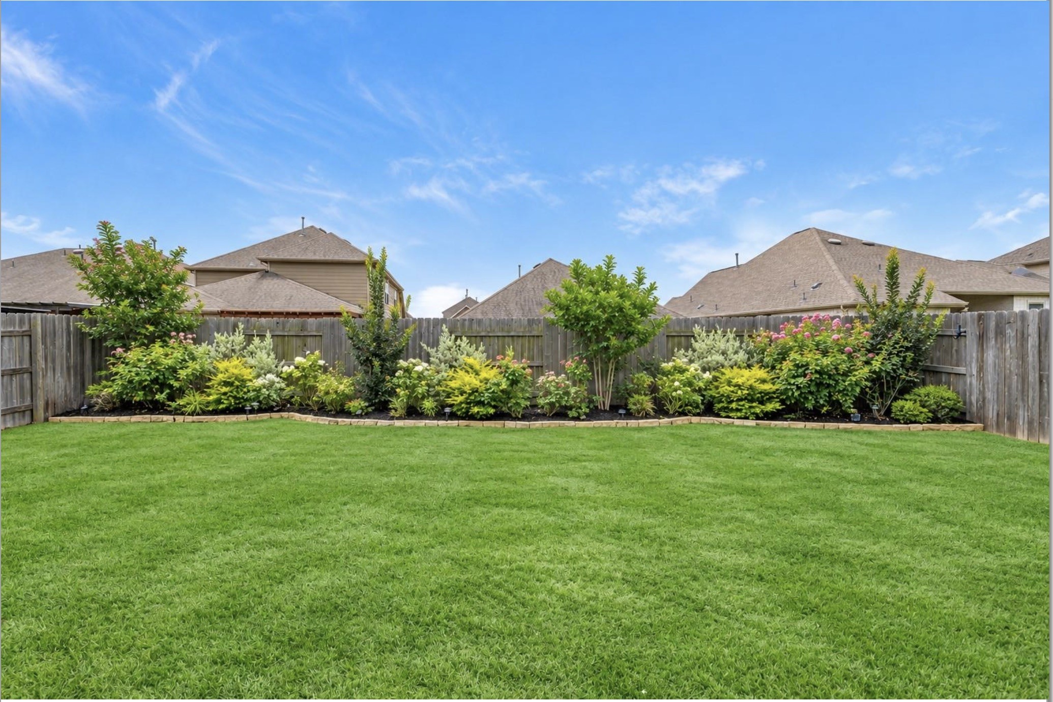 Generously sized fenced backyard with a lush green lawn and plenty of room for outdoor recreation, gardening, or future enhancements.