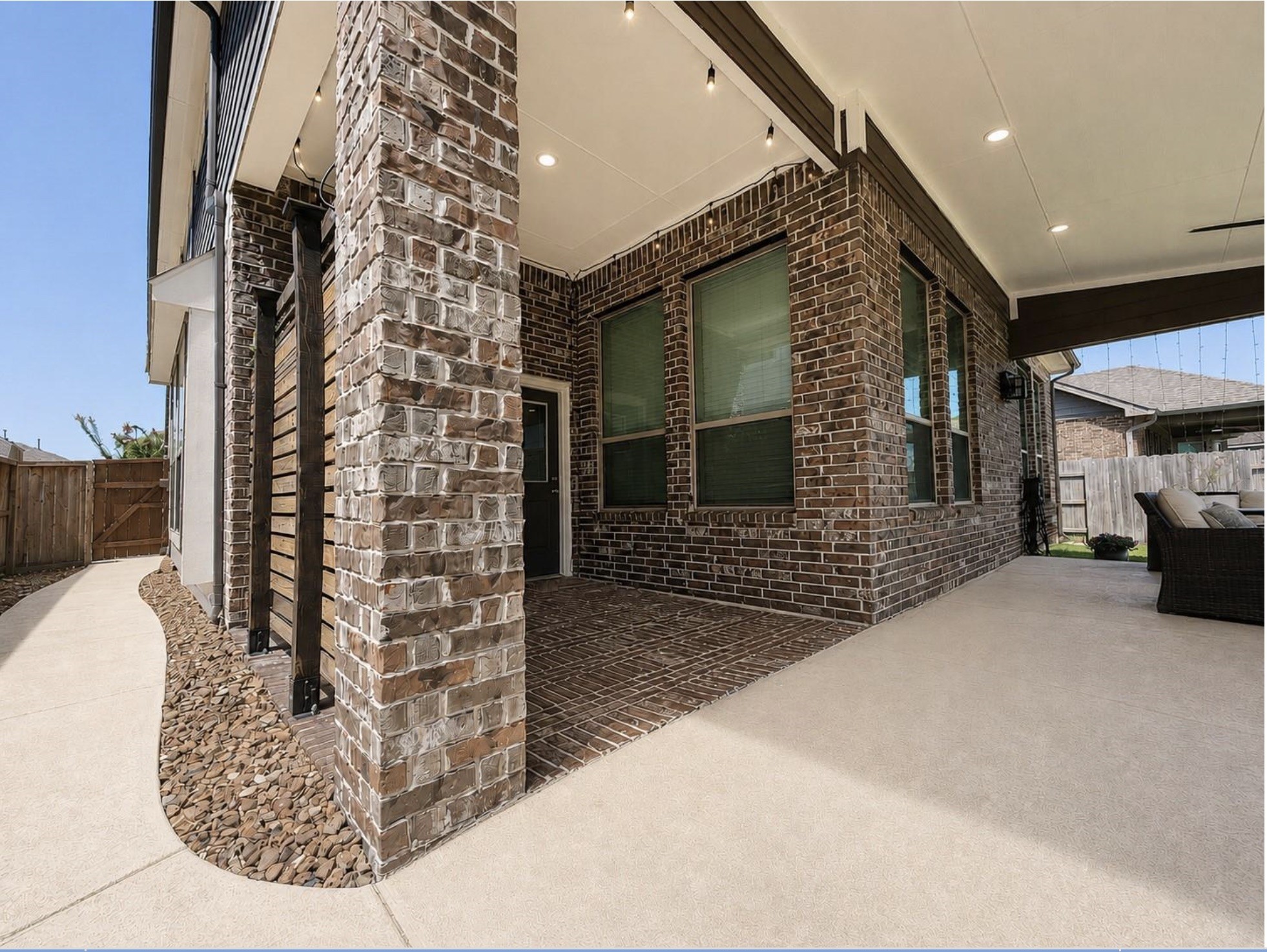 Attractive brick and stone exterior with an attached two-car garage, covered patio access, and a spacious driveway.