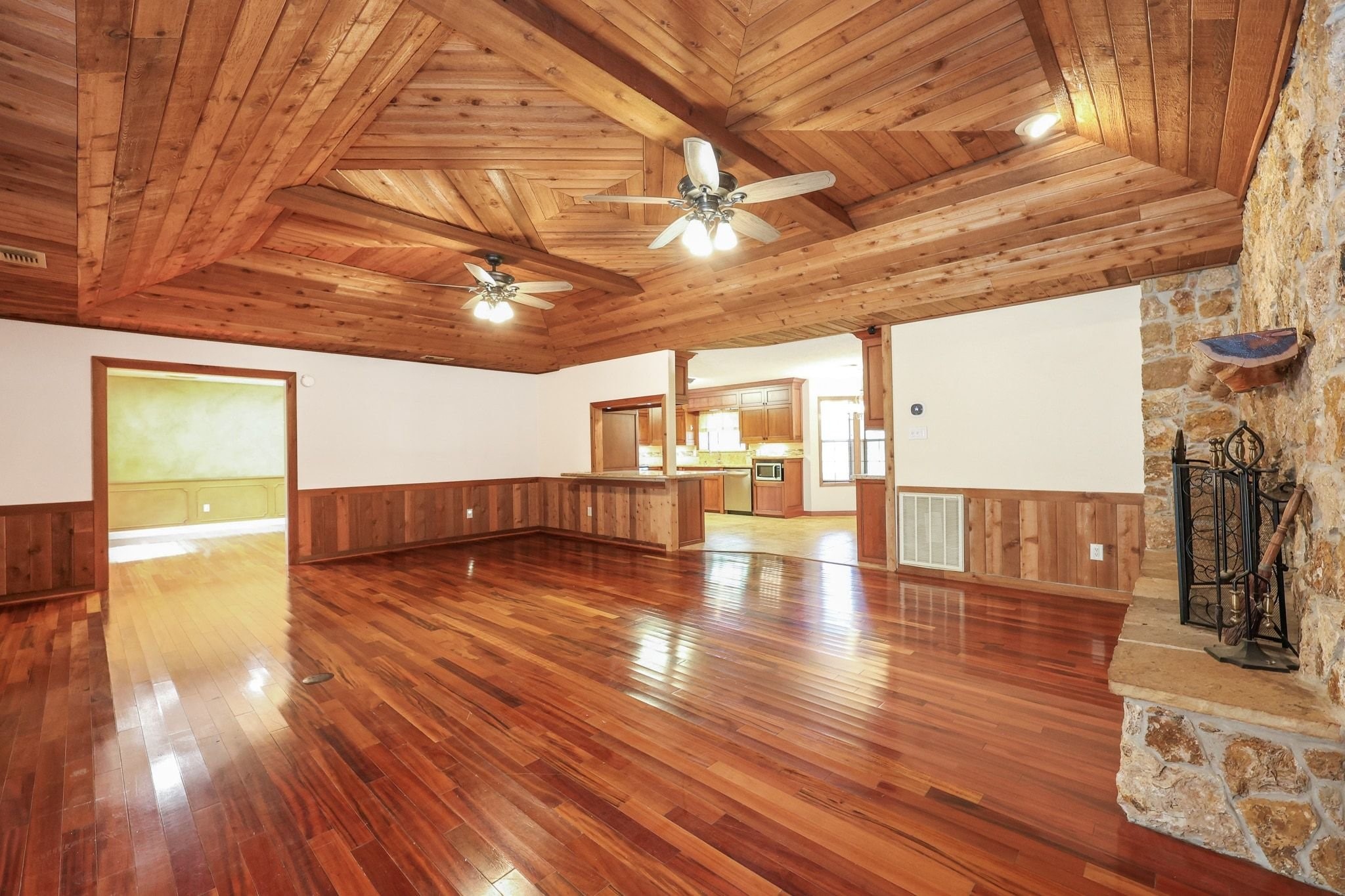 Large Family Room with a Beautiful Wood Ceiling and a Stone-Faced Wood-Burning Fireplace.