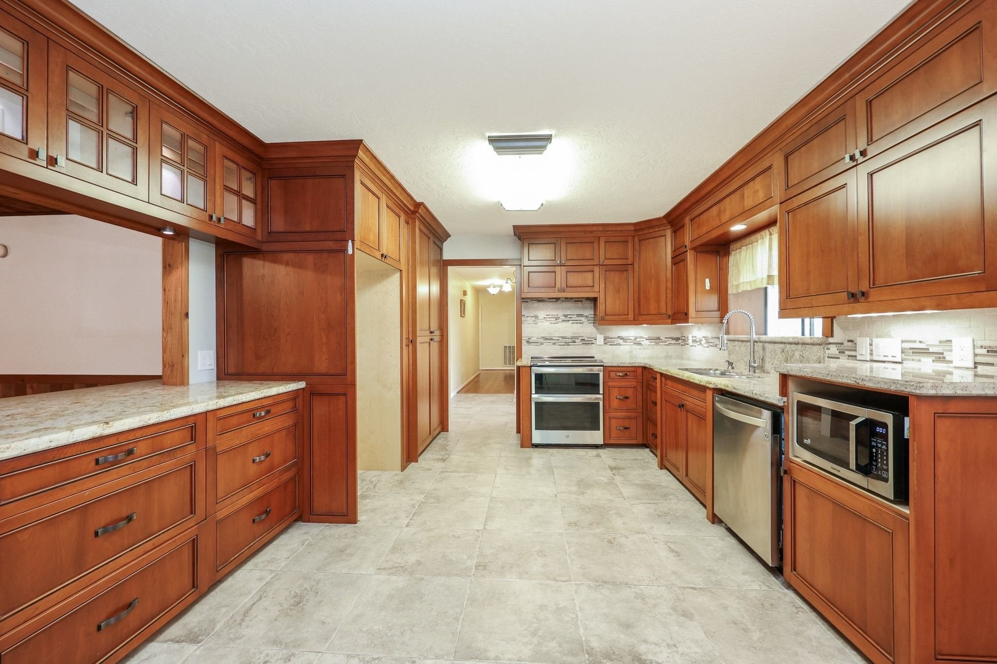 Kitchen with Custom Cabinets, a Double Electric Oven, Pantry Storage, Microwave Shelf has Beautiful Views of the Neighborhood Lake