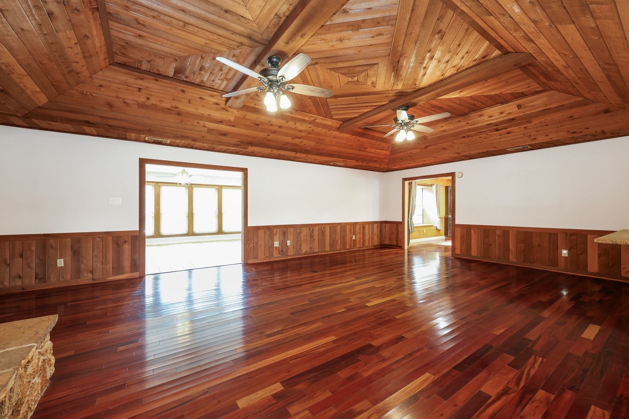 Large Family Room with a Beautiful Wood Ceiling and a Stone-Faced Wood-Burning Fireplace.