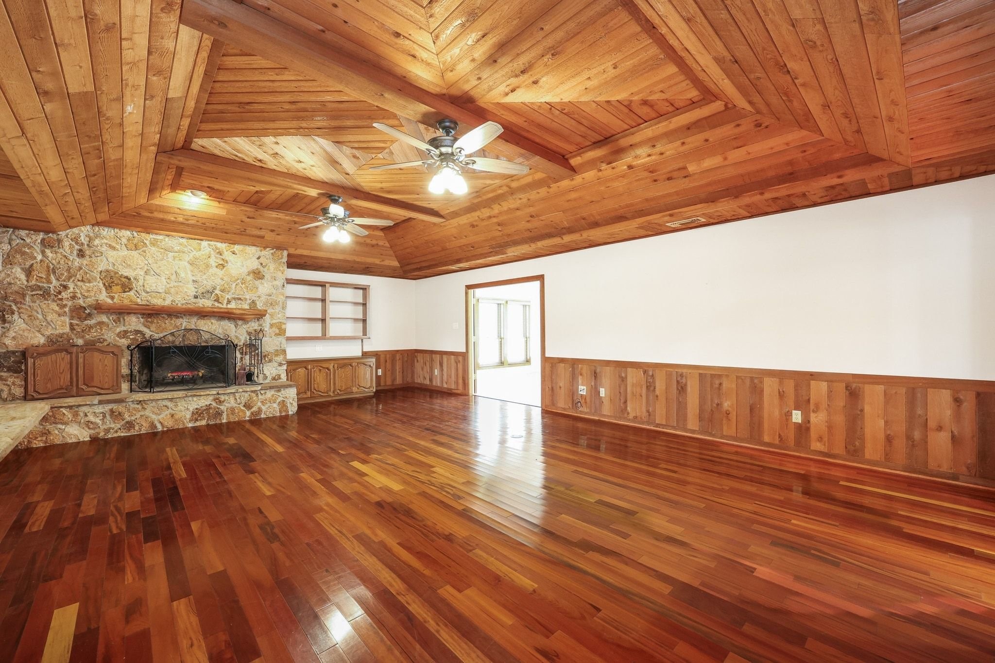 Large Family Room with a Beautiful Wood Ceiling and a Stone-Faced Wood-Burning Fireplace.