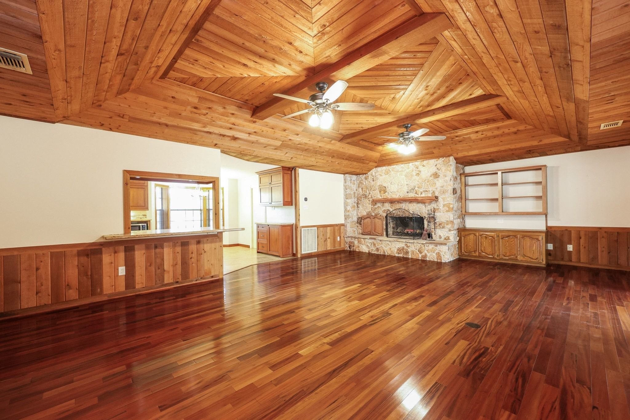 Large Family Room with a Beautiful Wood Ceiling and a Stone-Faced Wood-Burning Fireplace.