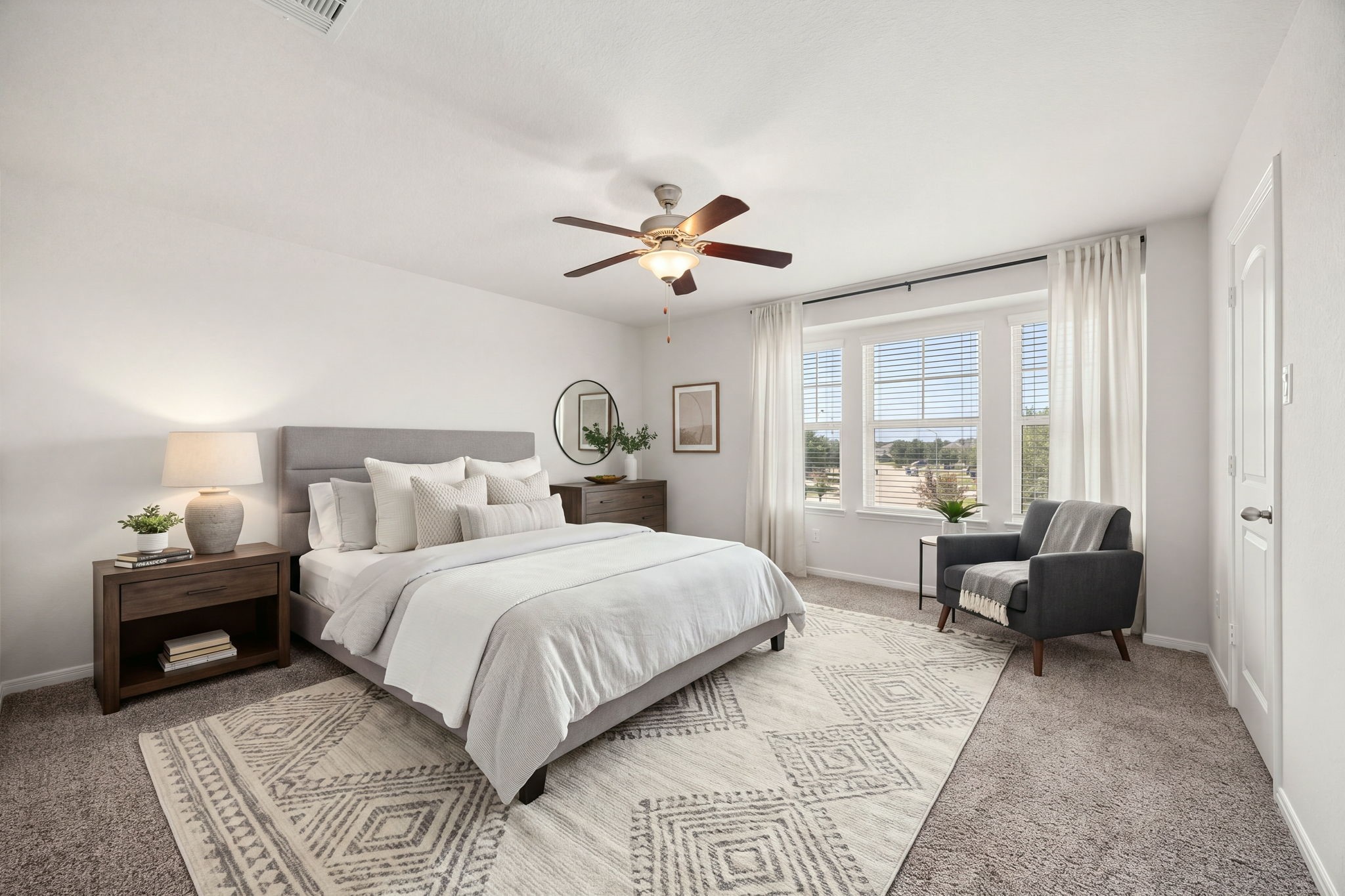 Sun-drenched secondary bedroom featuring a prominent three-panel feature window that captures expansive neighborhood views.
