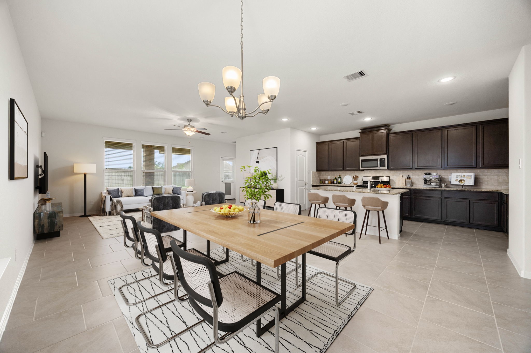 The spacious family room, dining area, and gourmet kitchen flow seamlessly together, creating the perfect space for entertaining or everyday living. Featuring an oversized island with seating, abundant cabinetry, and expansive windows overlooking the backyard, this home offers both style and functionality.