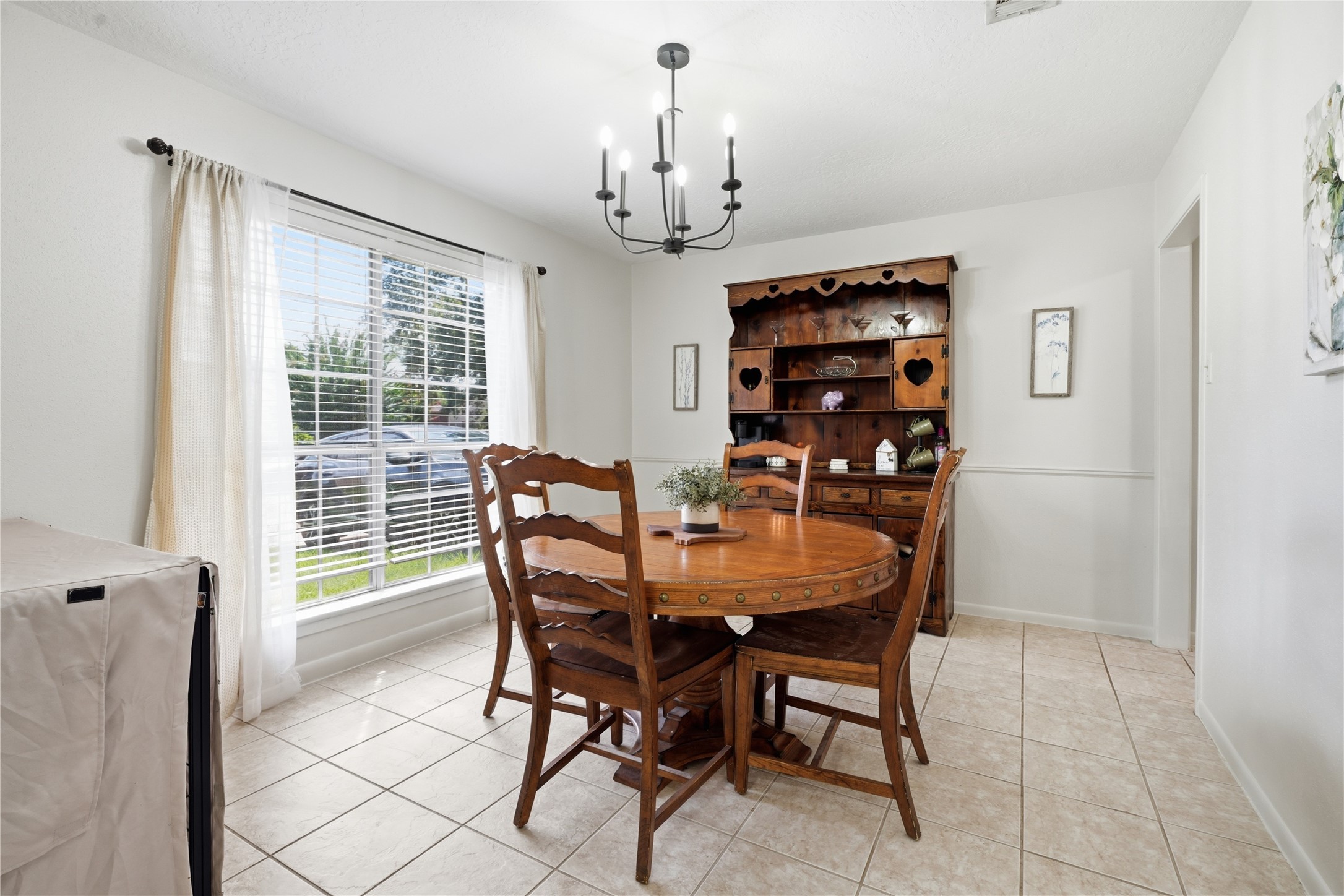 Spacious dining area with a large picture window, updated lighting, and plenty of room for meals and entertaining. Spacious dining area with a large picture window, updated lighting, and plenty of room for meals and entertaining.