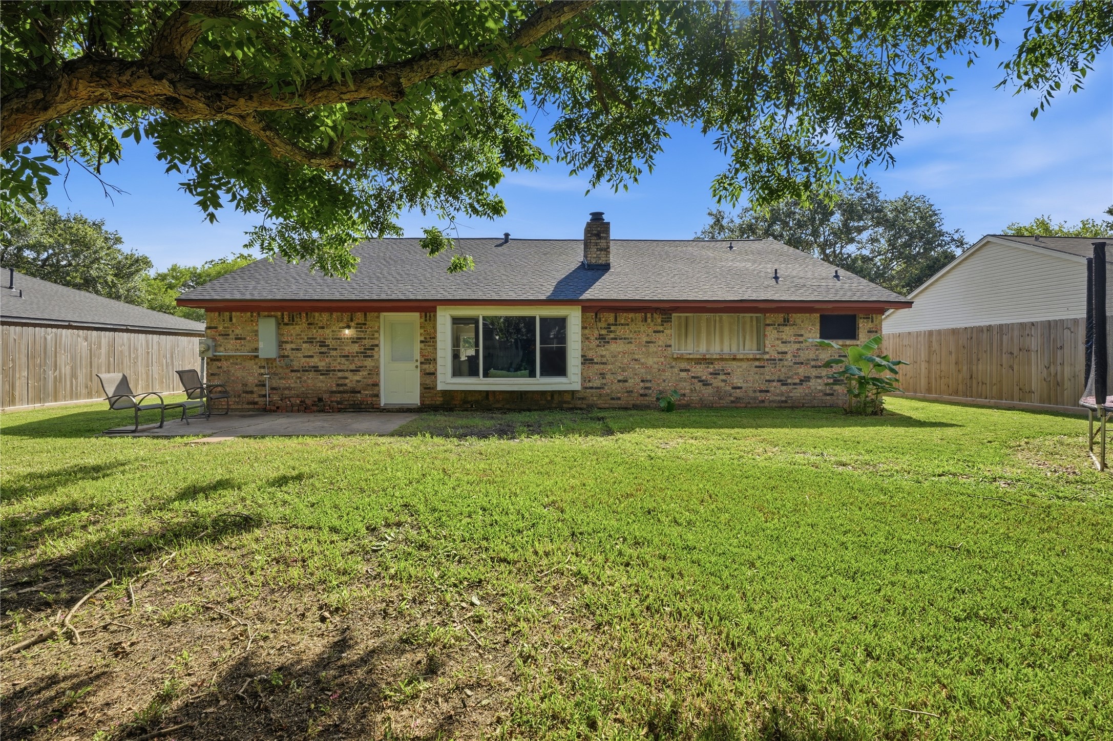 Large backyard featuring a patio, spacious lawn, and ample space for entertaining or relaxing outdoors.