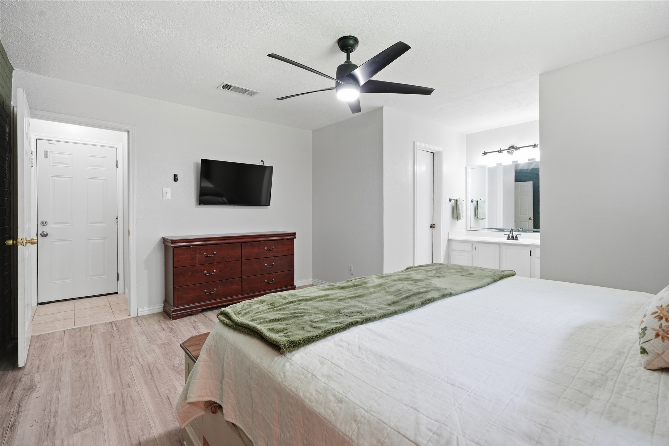 Alternate view of the primary suite showcasing the generous layout, ensuite bath access, and abundant wall space for furnishings.
