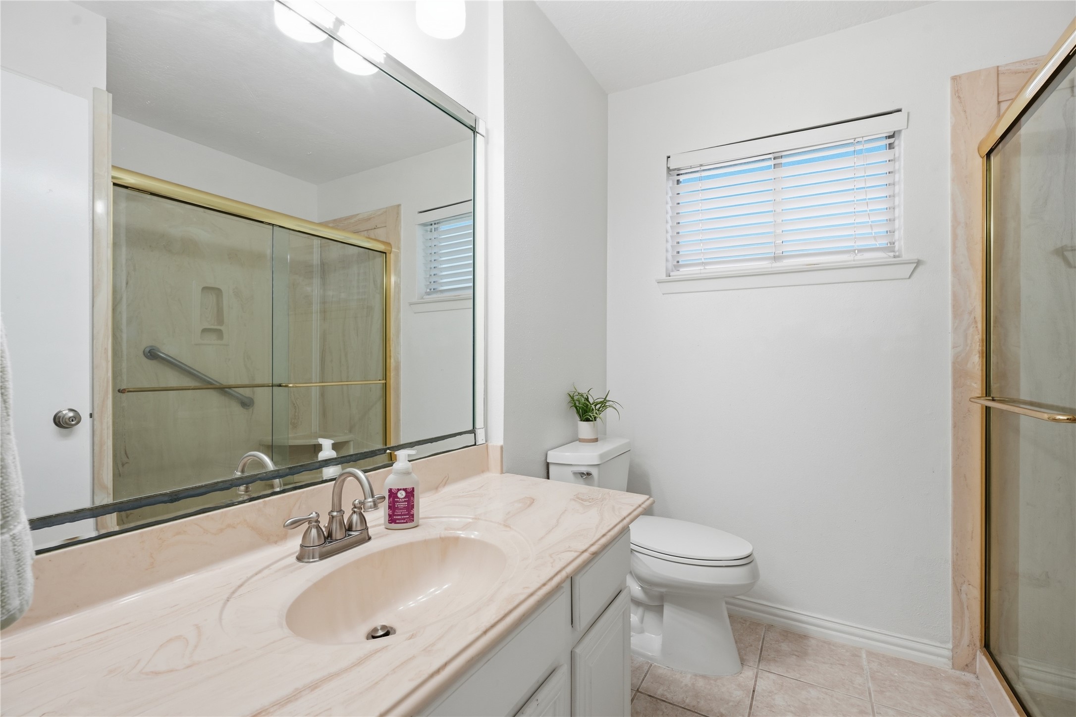 Secondary bathroom featuring an oversized vanity with ample counter space, a large mirror, and a walk-in shower.