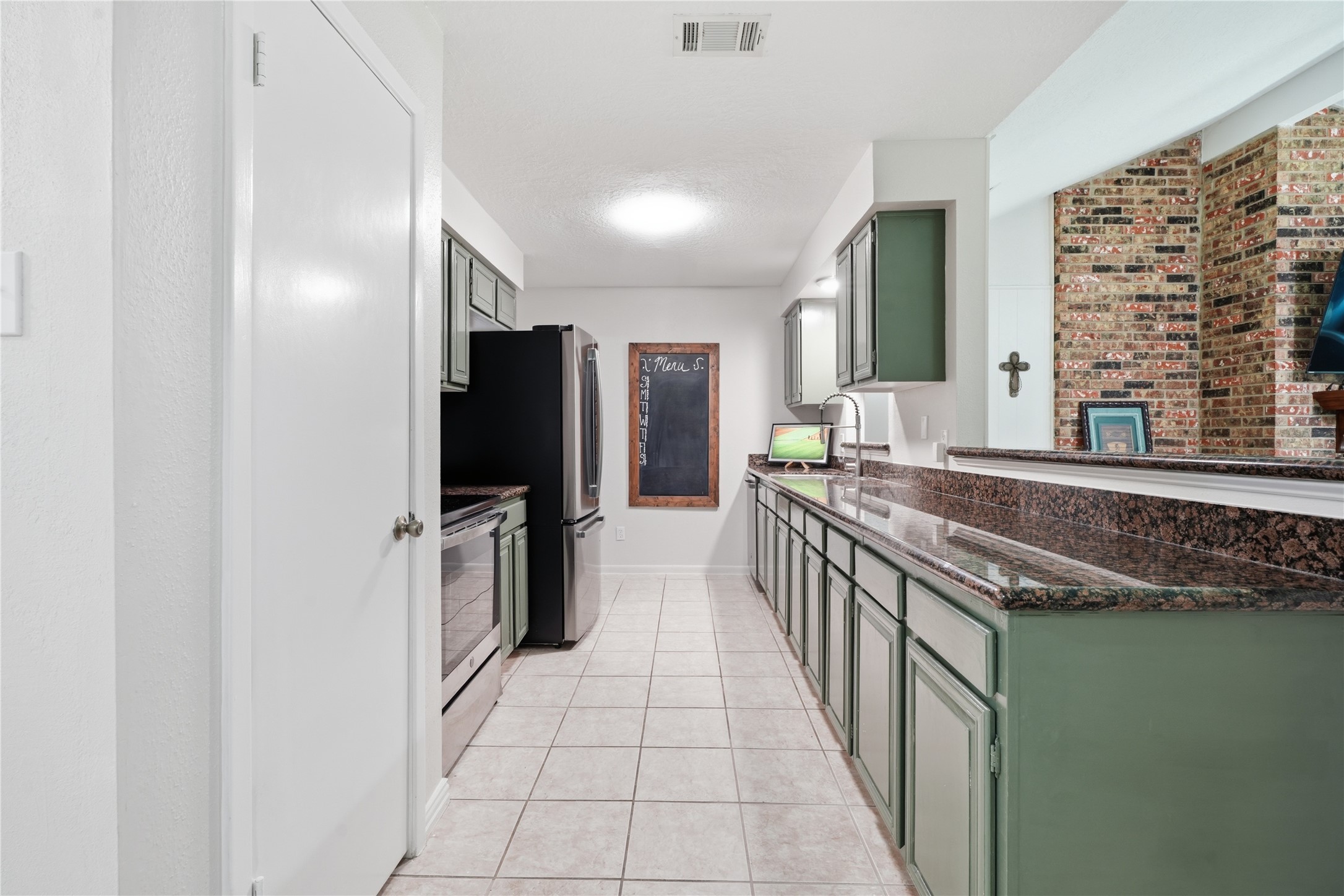 Long stretches of granite countertop provide generous prep space, complemented by stainless steel appliances and plentiful cabinetry.