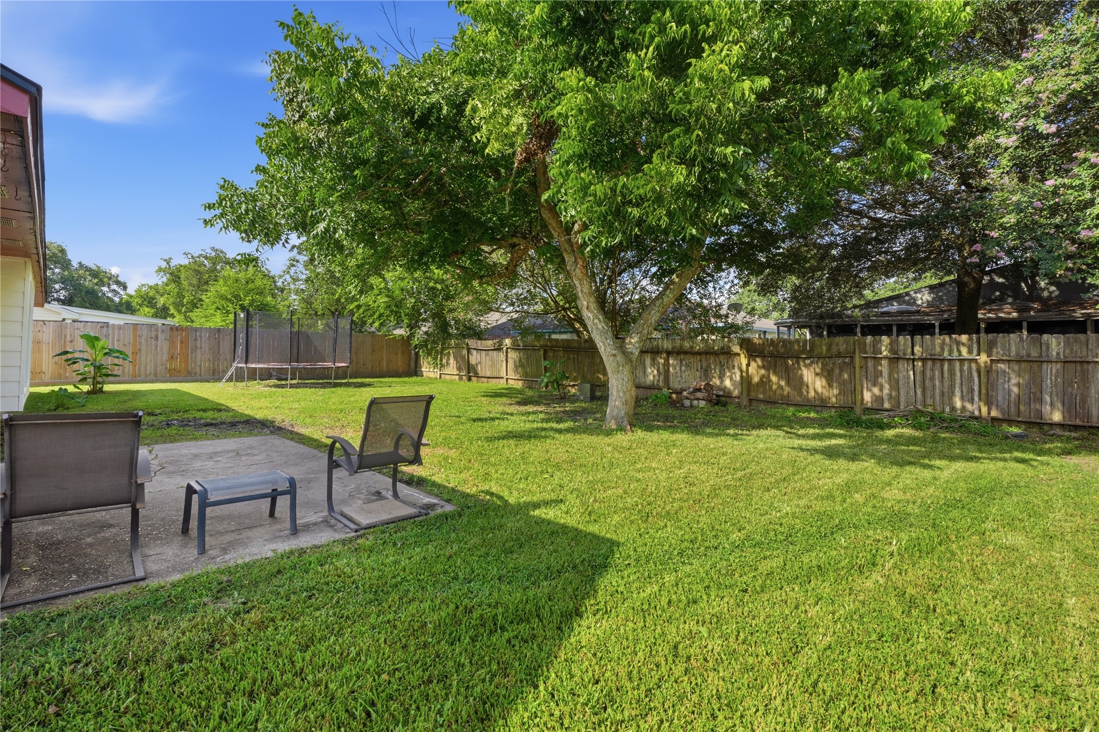 Private, fully fenced backyard with mature trees, a spacious lawn, and plenty of room for outdoor entertaining or hobbies.