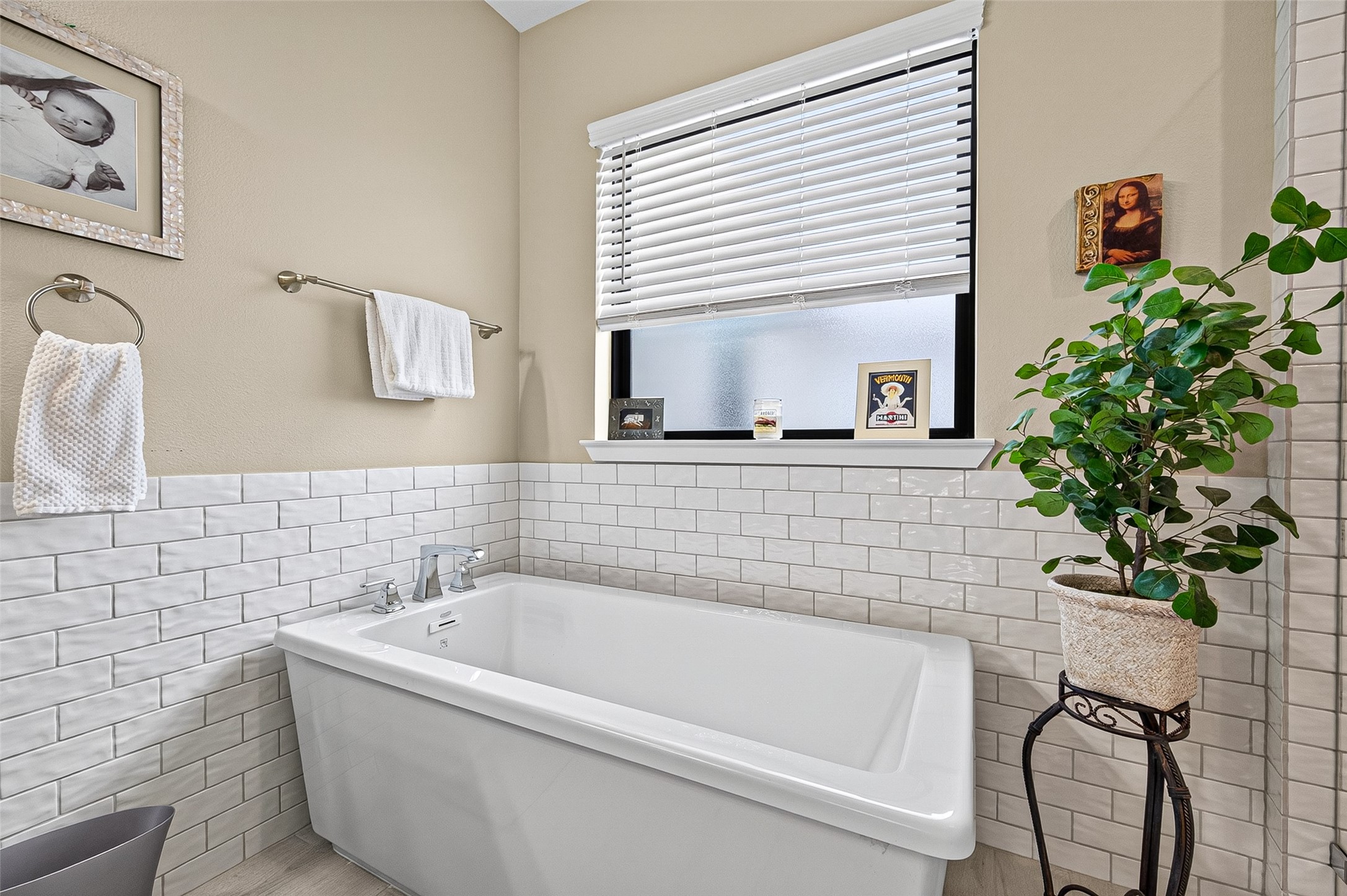 Large soaking tub under the frosted glass window allows space for a small table or chair if you like.