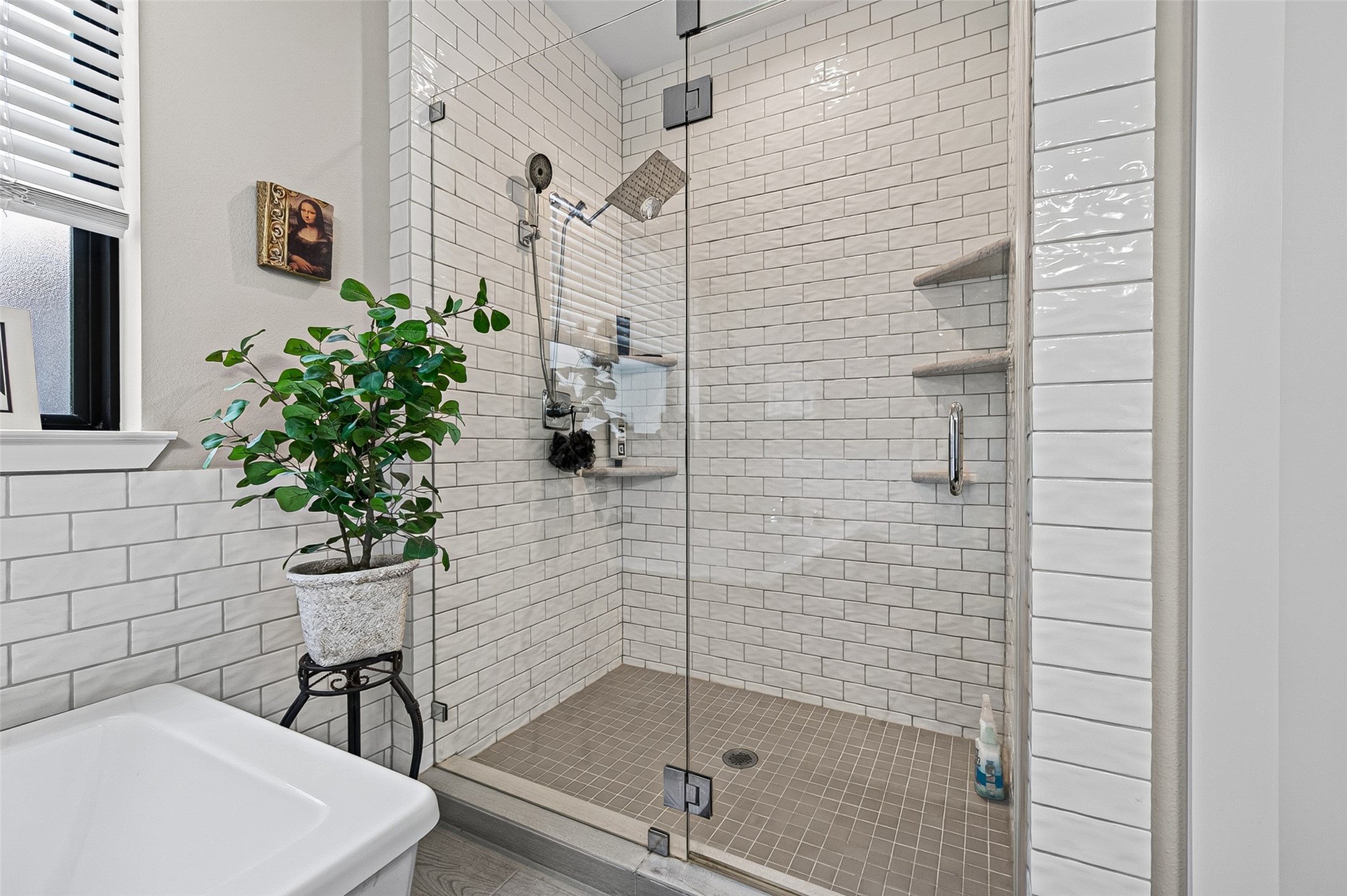 Oversized shower has corner shelving in both corners.