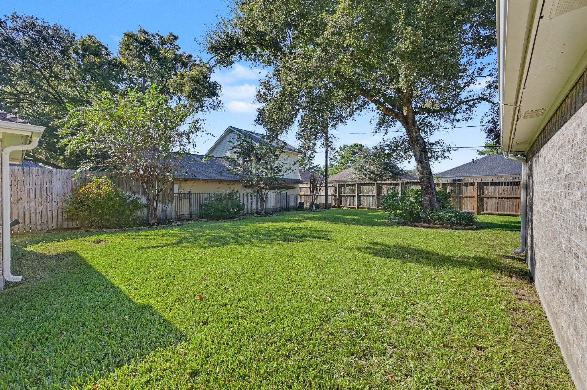 Another view of the backyard with lush green lawn, perfect for outdoor activities and relaxation.
