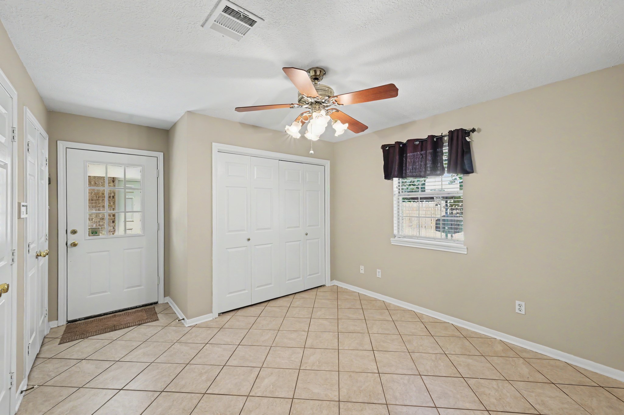 Bright office/study featuring tile flooring, ample natural light and a welcoming space with a FULL wall of convenient closet storage space! Includes a laundry closet, too.