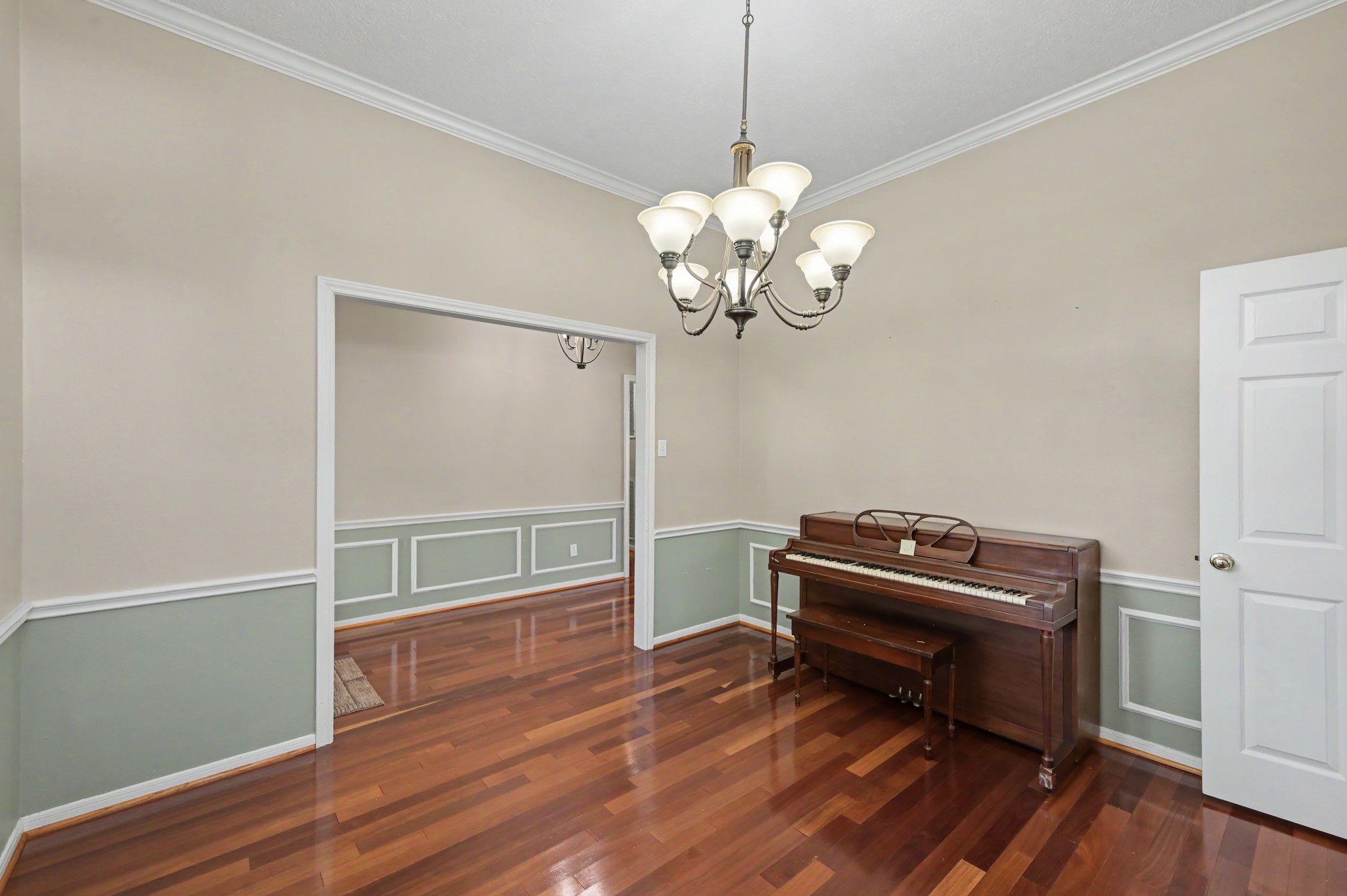 Elegant dining room with rich hardwood floors, wainscoting, and bathed in natural light.