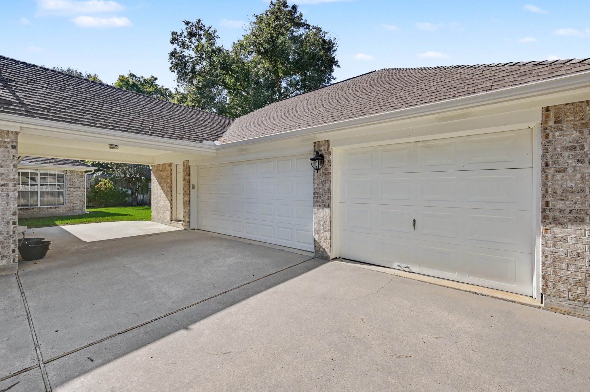 Spacious driveway leading to a 3-car garage, complemented by a charming covered entryway from the home.