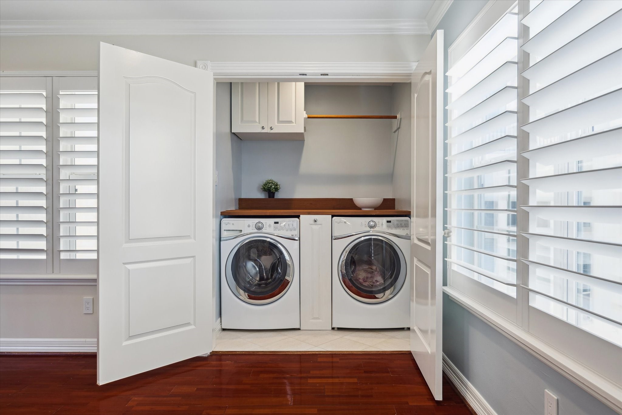 Compact, efficient laundry area neatly enclosed with practical shelving.