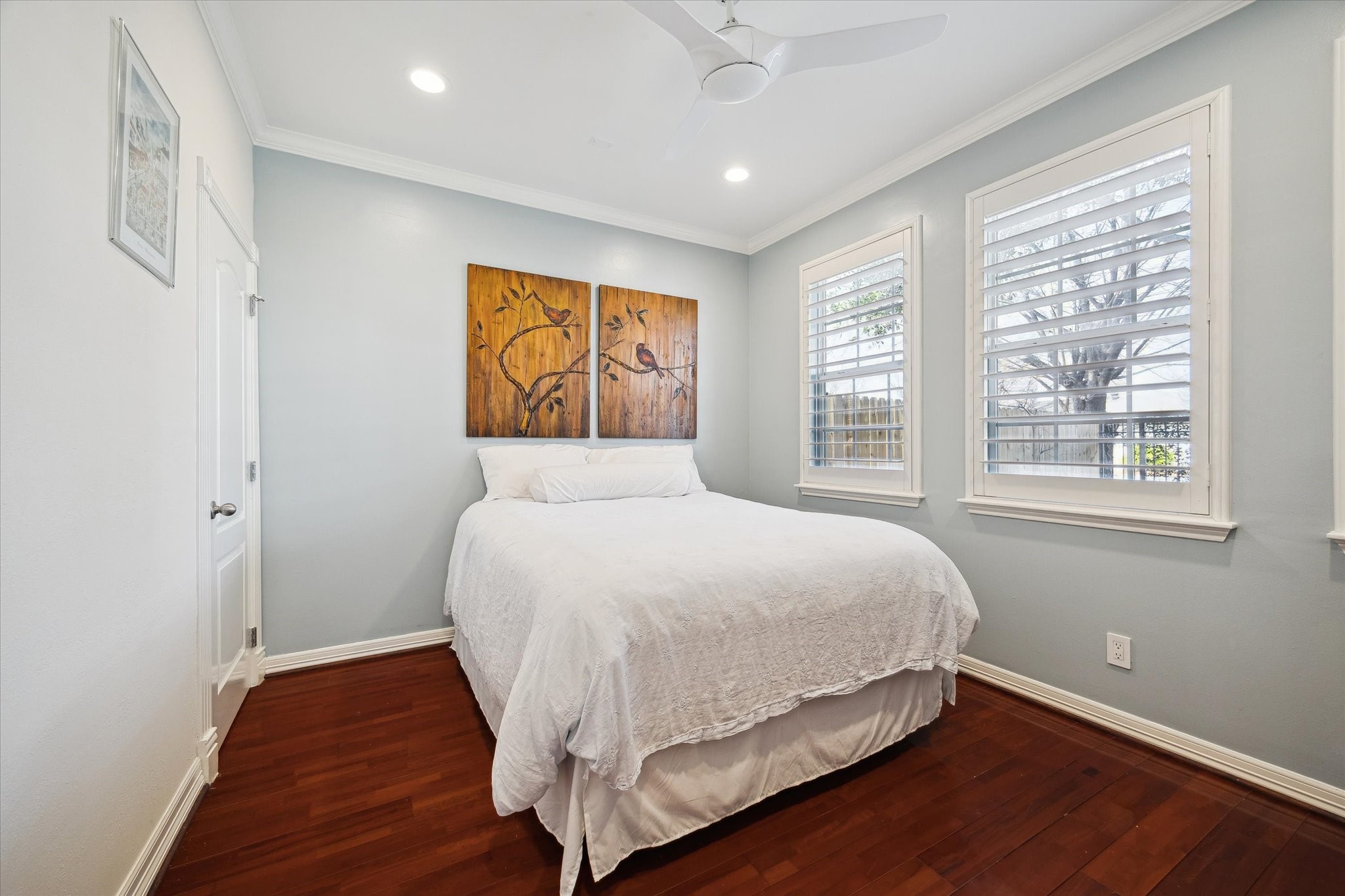 First floor bedroom features hardwood floors,  a closet, and windows with plantation shutters overlooking the front yard. There is a second  walk in closet in the hallway.
