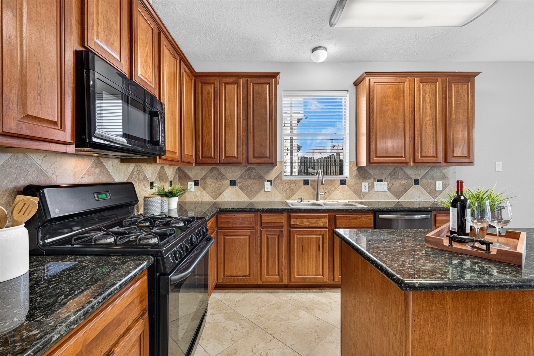 Chic tile backsplash and gleaming granite countertops offer a stylish yet practical space where cooking feels like a joy rather than a chore.