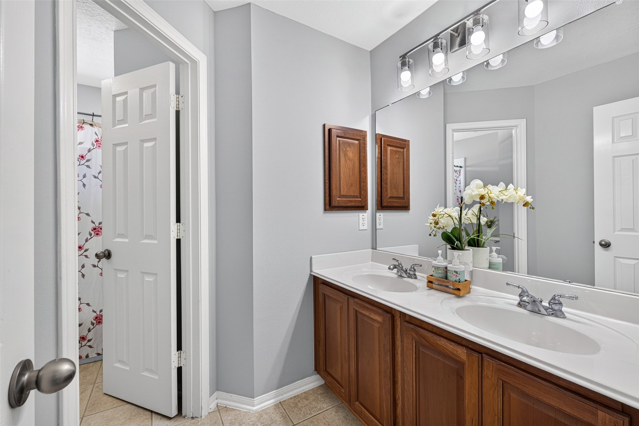 Bright and stylish, this upper-level bathroom features an expansive double-sink vanity with beautiful wood cabinetry and plenty of counter space for seamless morning routines.