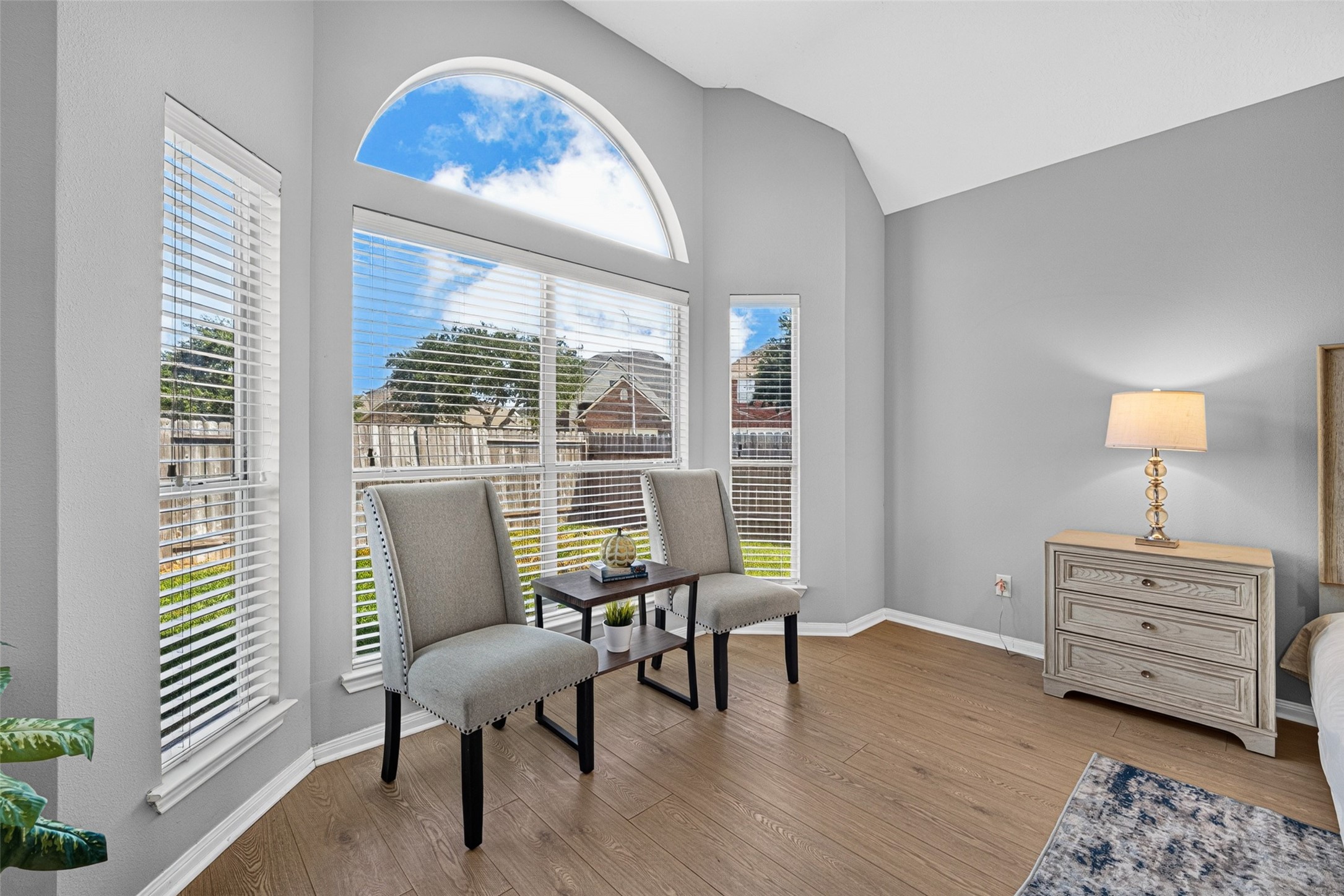 Beautiful arched windows overlook the peaceful backyard, offering picturesque views and a soothing atmosphere to wake up to each morning. A cozy private sitting area provides the perfect nook to curl up with a good book or enjoy a moment of quiet reflection.