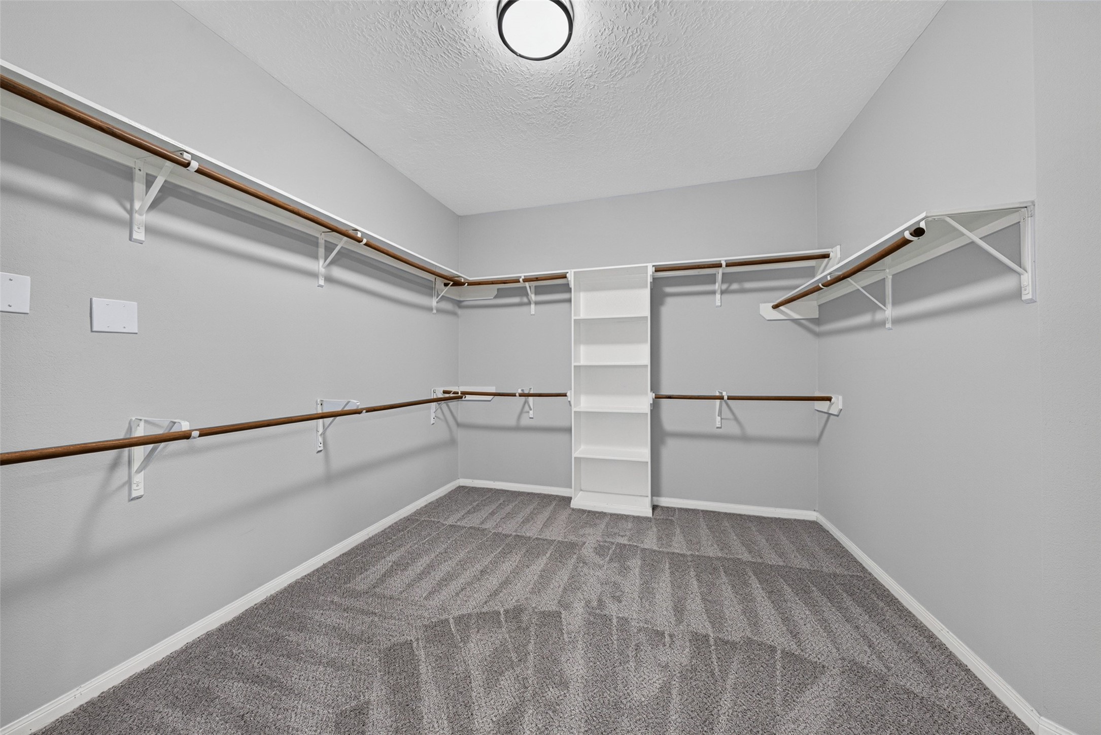 Expansive and brilliantly organized, this primary walk-in closet is equipped with custom built-in shelving, multi-level hanging rods, and specialized shoe storage cubbies.