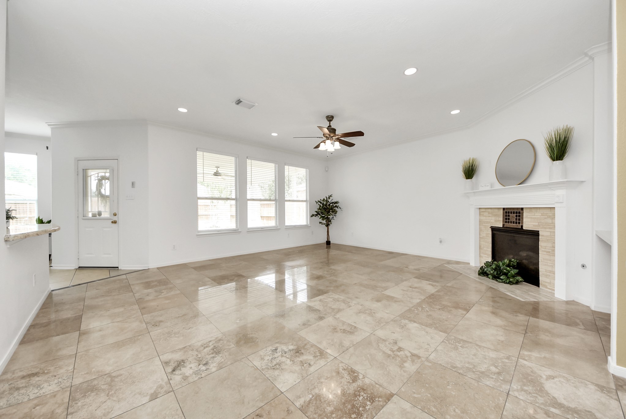 Beautiful travertine flooring extends throughout the main living area, creating warmth, durability, and a seamless foundation for both everyday life and entertaining.