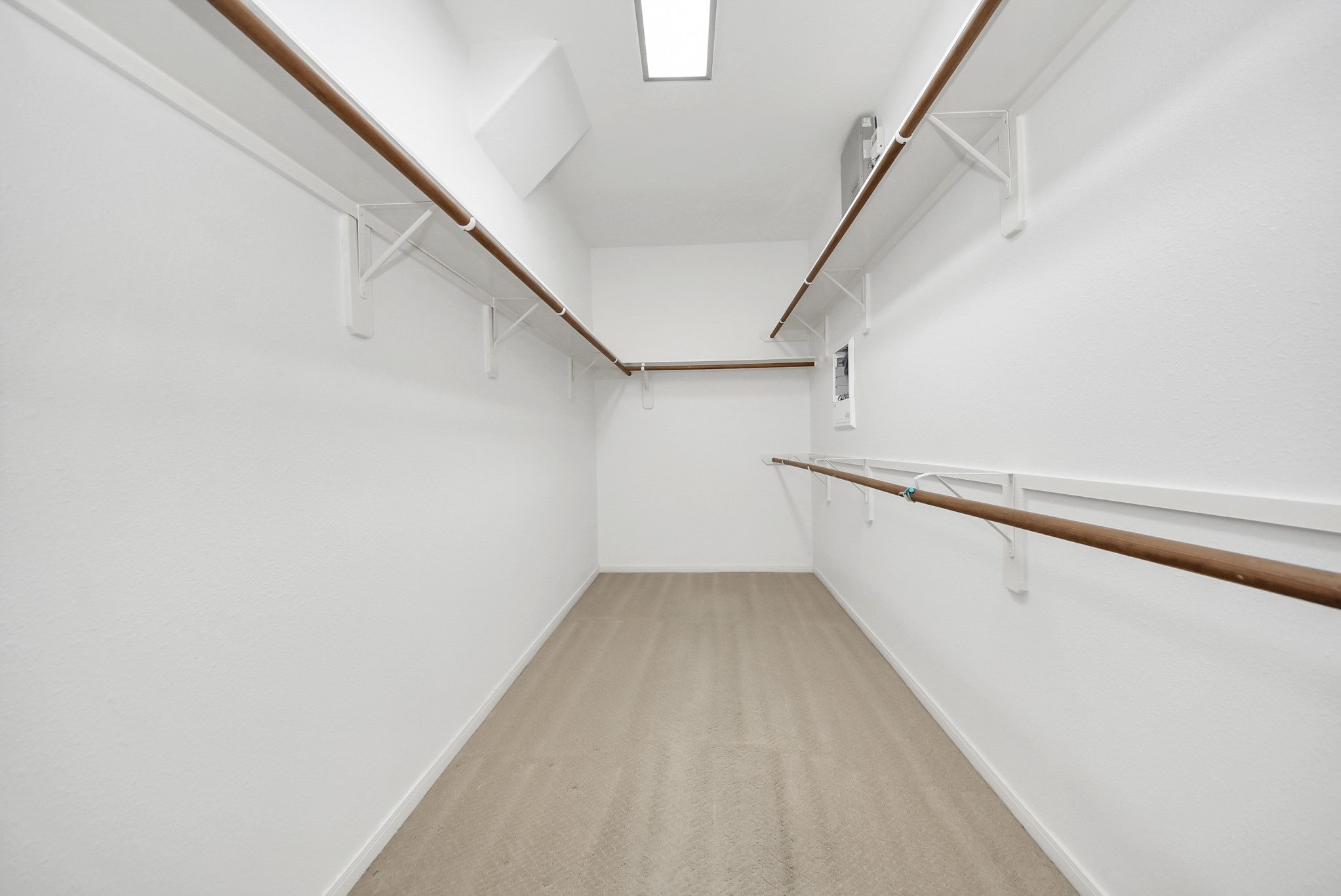 Designed to maximize storage and organization, this spacious walk-in closet features upper and lower hanging areas along with additional shelving to help keep everything neatly in its place.