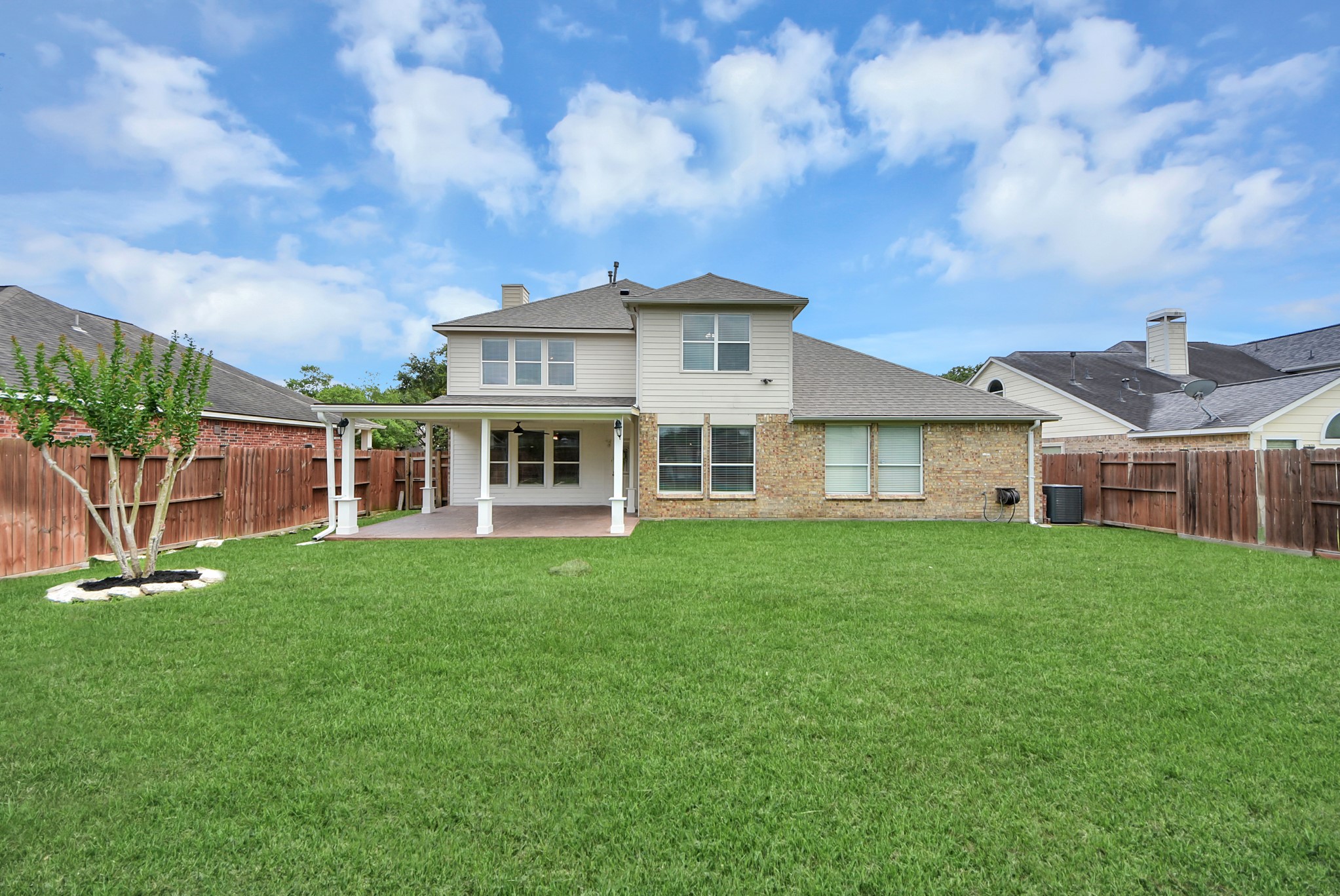 The backyard offers the perfect blend of comfort and space, featuring a covered patio for shaded outdoor enjoyment and plenty of green space for play, pets, gardening, or relaxing evenings outside.