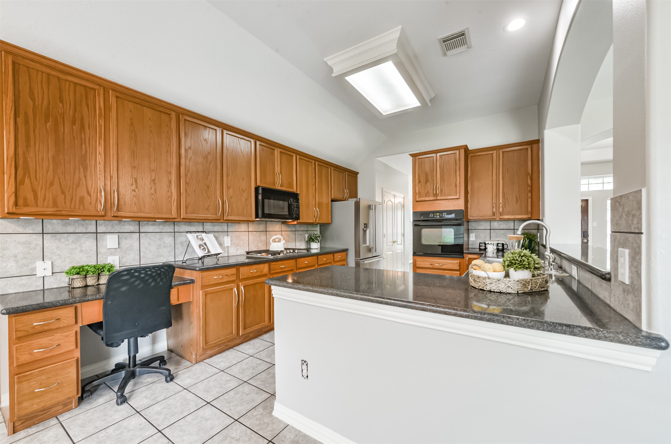 Spacious kitchen with plentiful cabinetry, recent appliances (refrigerator, dishwasher, stove top)