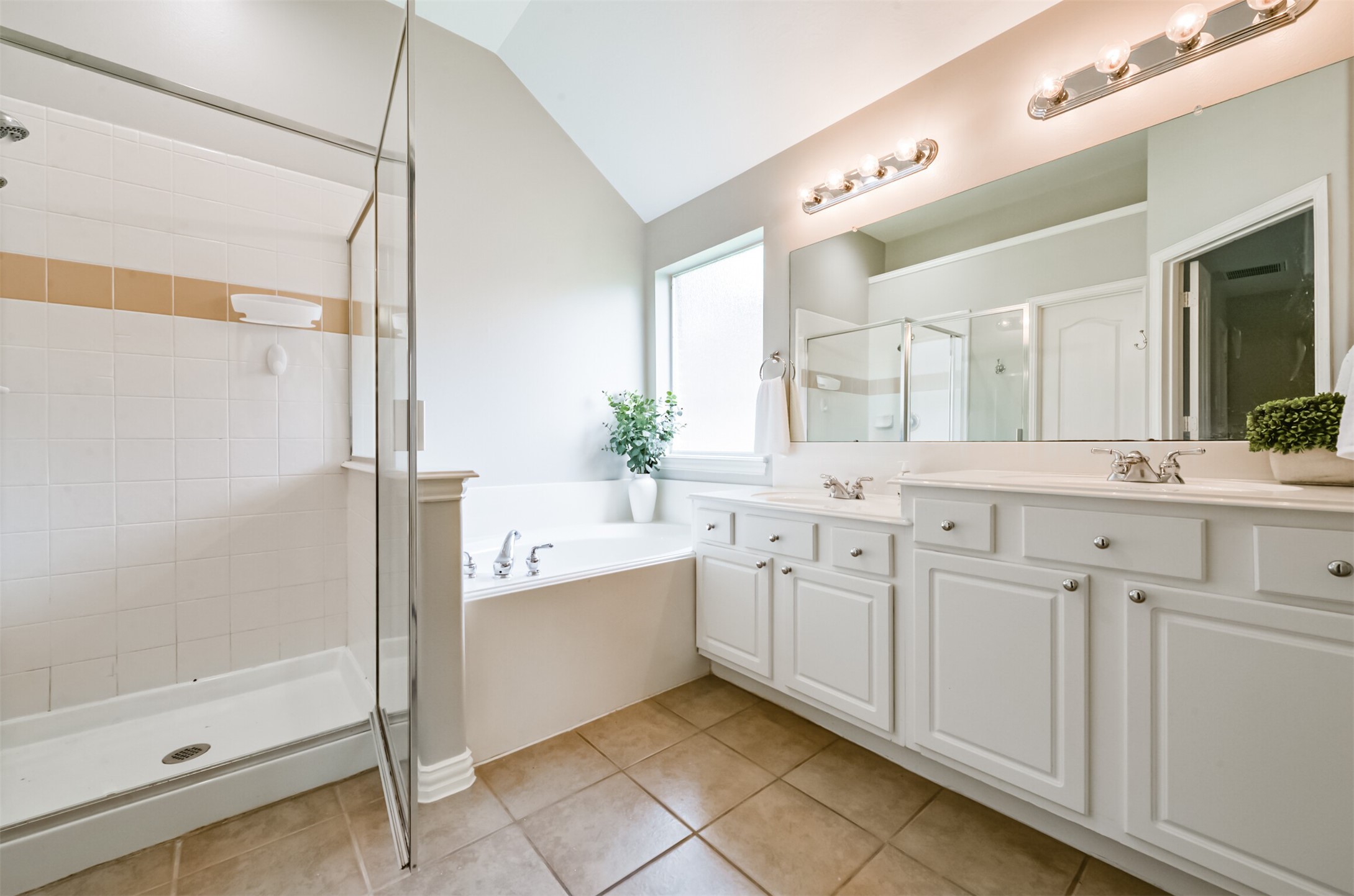 Primary bath has tub, separate shower, and dual sinks.