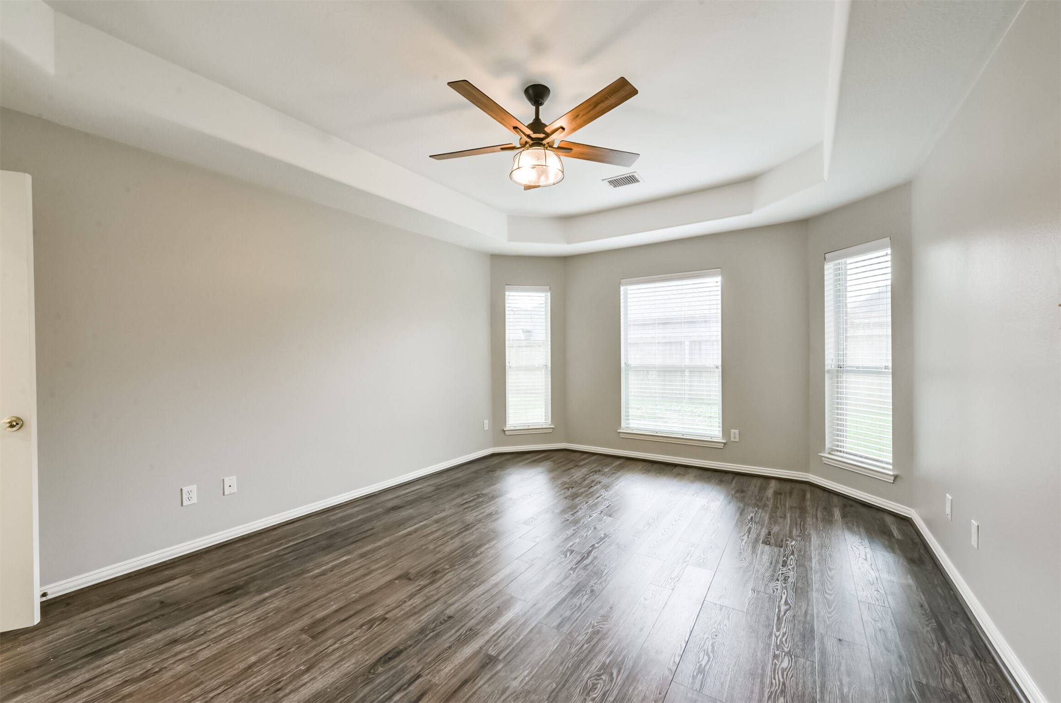 Large primary bedroom with tray ceiling.