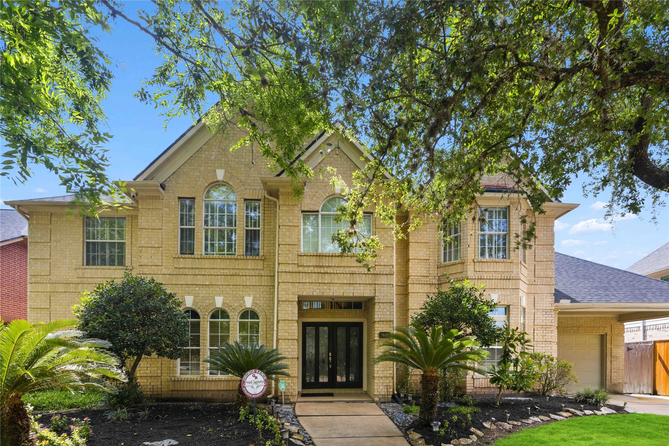 Welcome to a home that has it all, featuring 5 bedrooms and 3.5 baths in Greatwood. The grand two-story light brick exterior is accented by arched windows, mature trees, and a concrete walkway leading to the double-door entry.